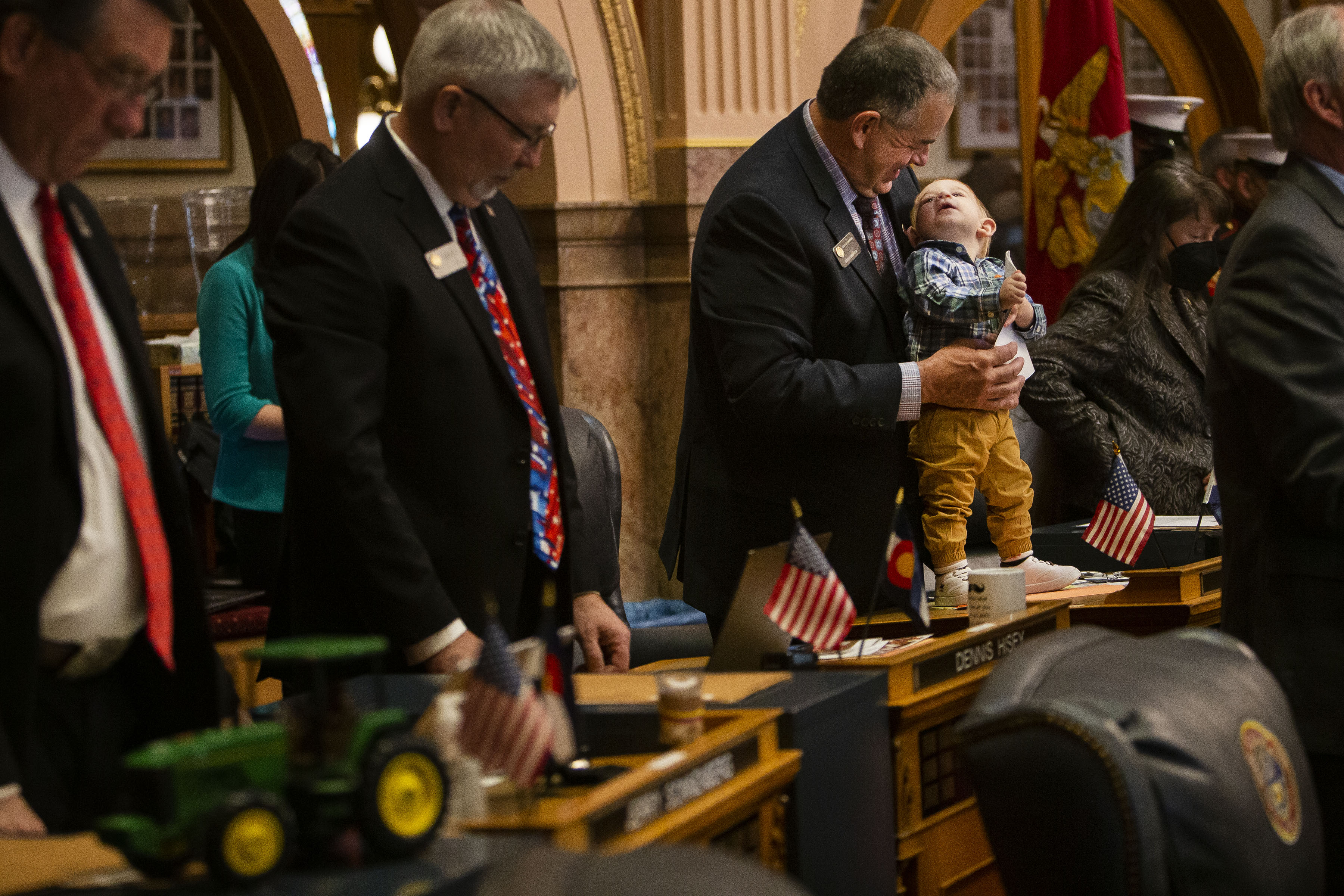 Sen Cleave Simpson looks down to his grandson Connor Simpson, 1, during the prayer that starts off the first day of Colorado's 2022 session in the Senate Chambers at the Colorado State Capitol Building on Wednesday, Jan. 12, 2022, in Denver, Colo. (Timothy Hurst/The Gazette) (Timothy Hurst)