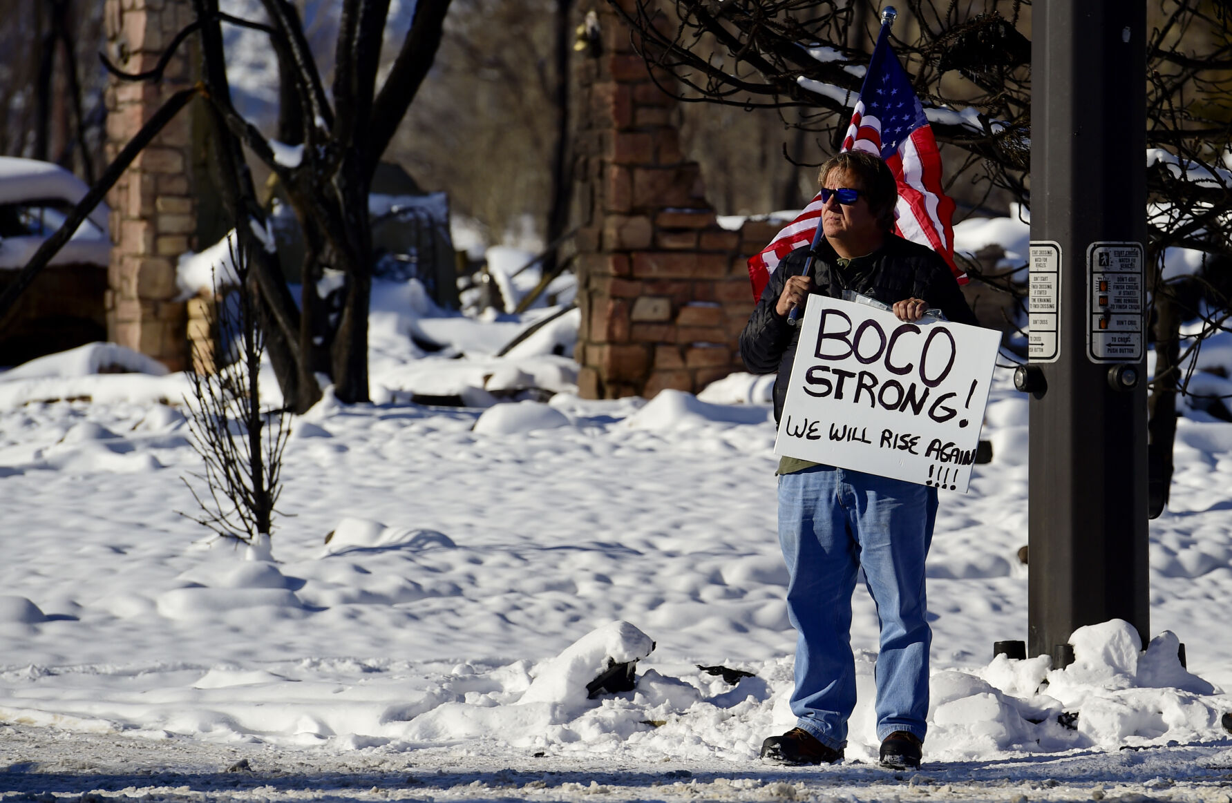 LOUISVILLE, CO - JANUARY 2:A man holds the flag and a sign reading