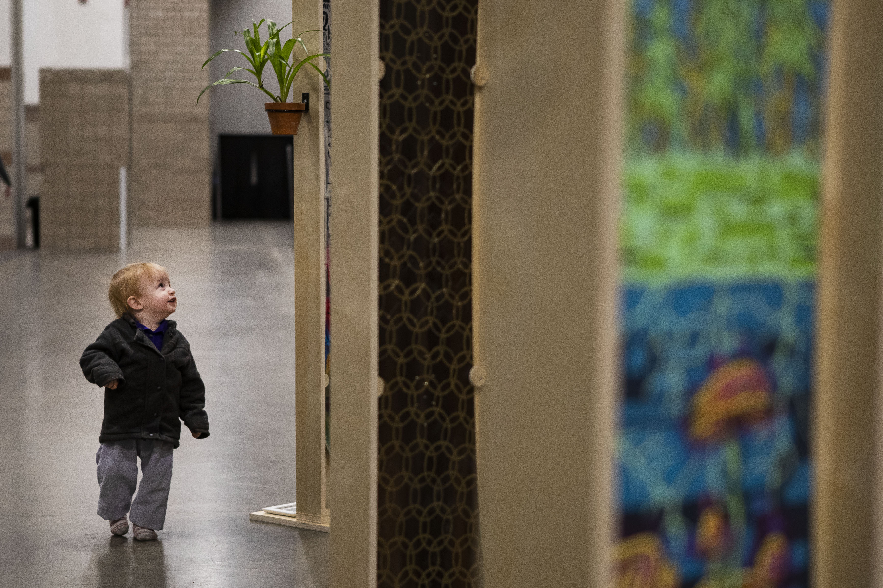 A young child who’s name was not given is enthralled by a series of snowboards shaped and painted by artists on display during the second day of the Outdoor Retailer Snow Show at the Colorado Convention Center on Thursday, Jan. 27, 2022, in Denver, Colo. (Timothy Hurst/The Gazette) (Timothy Hurst/The Denver Gazette)