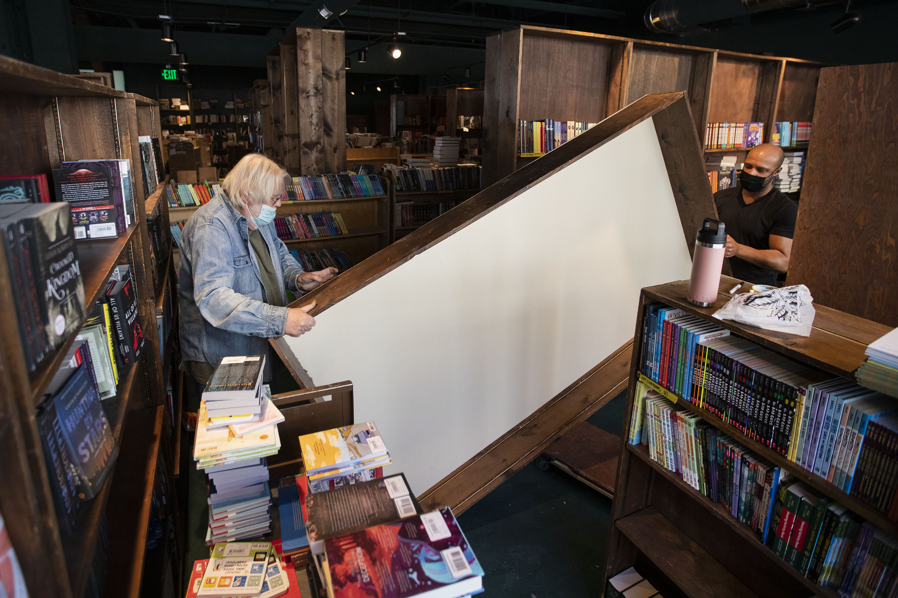 Tattered Cover Book Store CEO Kwame Spearman, right, and Ron Dirlam carry a new bookshelf into place Tuesday in the children’s section in preparation of the store opening its newest location in Westminster, Colo. Dirlam has built all the shelves for all of the Tattered Cover’s new locations. (TimHursttim.hurst@gazette.comhttps://secure.gravatar.com/avatar/aca82bd62b4ee425c598527cd6faa1b1?d=mm&r=g)