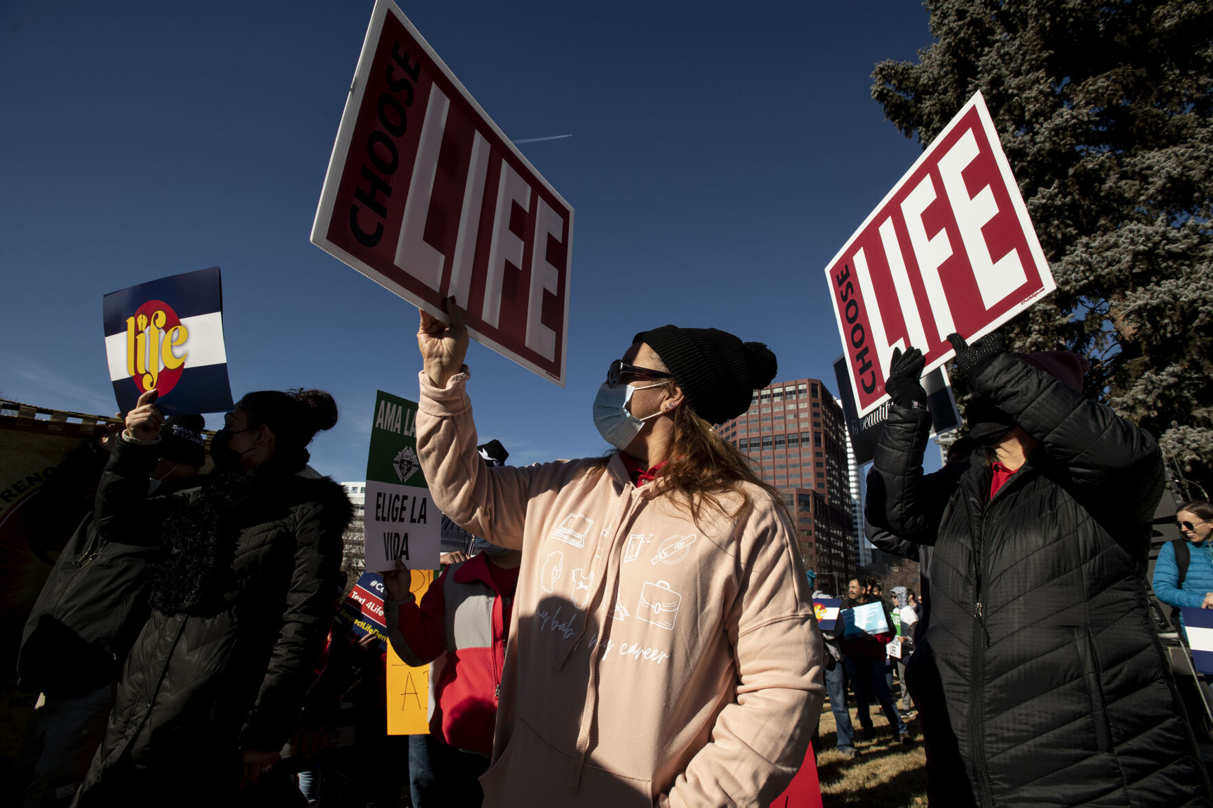 People hold signs during the Celebrate Life Rally and March. Optimism was high that Roe v. Wade will be overturned. “It certainly gives us more hope,” said eventgoer Eric Golesh of Arvada, who attended with his wife and four children. (Chancey Bush/ The Gazette)