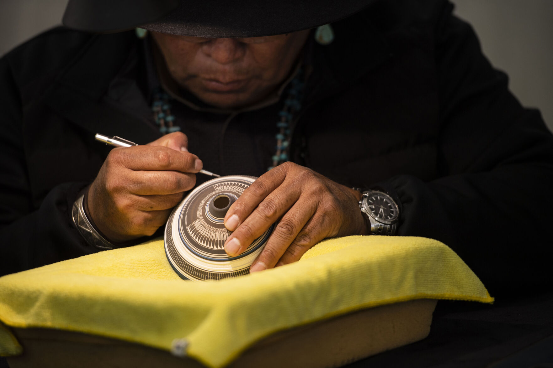 Diné pottery artist Bob Lansing, from Cortez, Colo., works on etching designs during the Colorado Indian Market and Southwest Art Fest at the Colorado Springs Event Center in Colorado Springs on Friday, Jan. 14, 2021. The event features 150 artists and craftsmen, including tribal dancers, award-winning entertainers, artist demonstrations, and special attractions. The festival kicked off on Friday and runs through the weekend, Saturday and Sunday from 10 a.m. to 5 p.m. (Chancey Bush/ The Gazette) (Chancey Bush/ The Gazette)