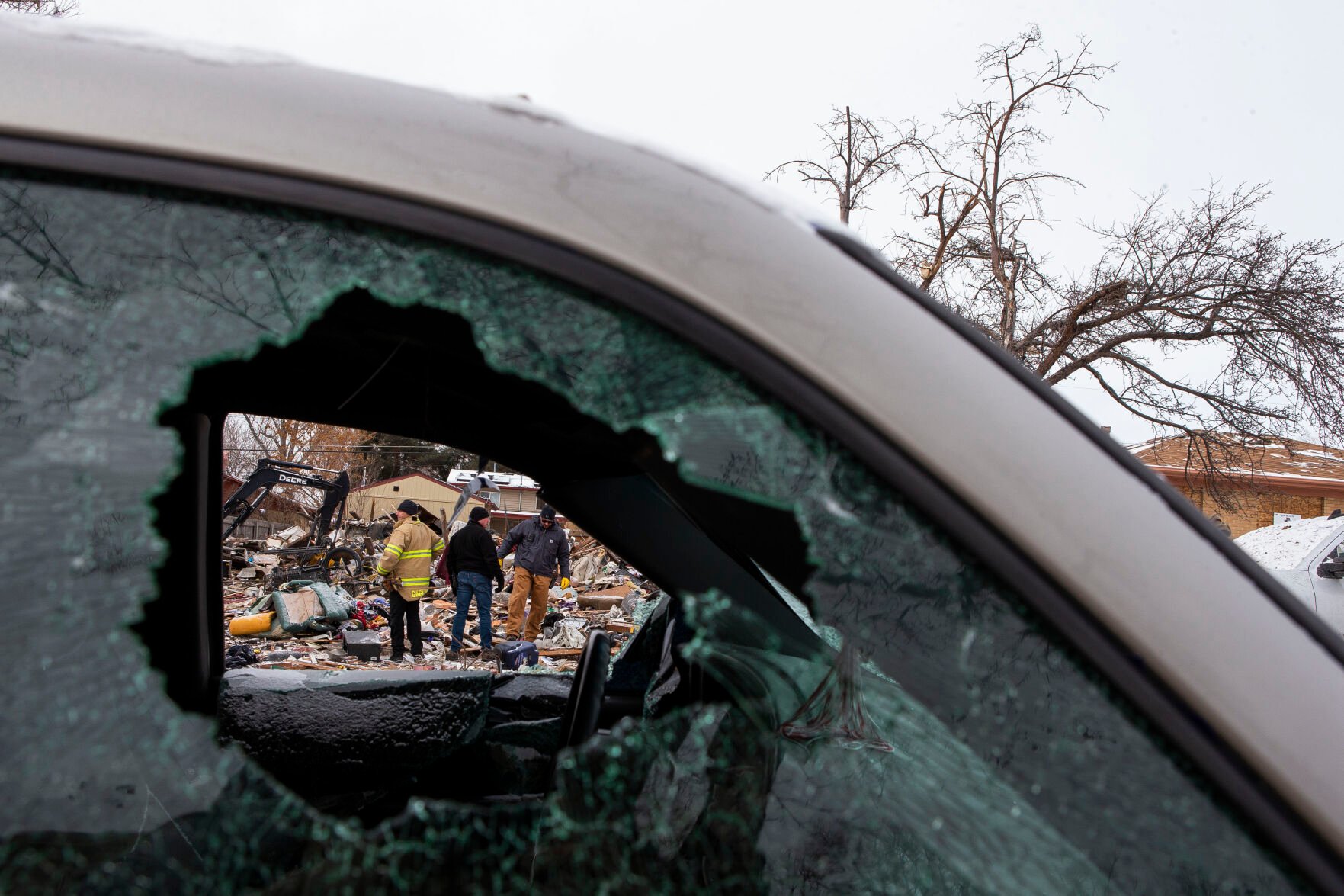 Crews can be seen through the broken windows of a truck across the street from a home that exploded on the 7700 block of Knox Court on Tuesday, Feb. 22, 2022, in Westminster, Colo. (Timothy Hurst/The Denver Gazette) (Timothy Hurst)