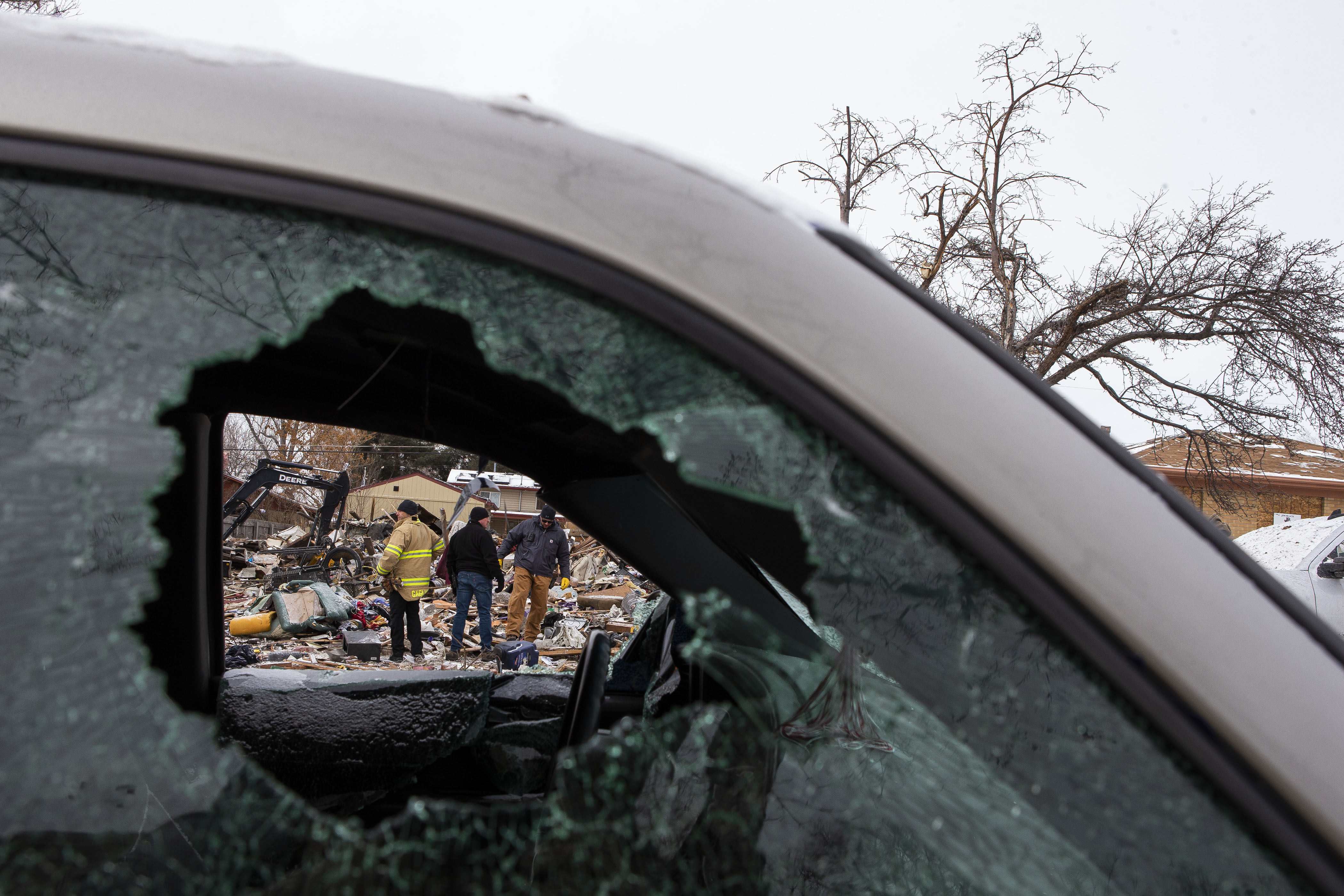 Crews can be seen through the broken windows of a truck across the street from a home that exploded on the 7700 block of Knox Court on Tuesday, Feb. 22, 2022, in Westminster, Colo. (Timothy Hurst/The Denver Gazette) (Timothy Hurst)
