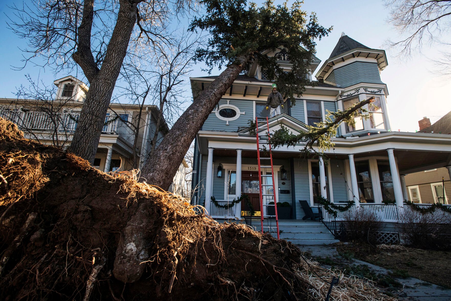 Arborist Tony Bell, co-owner with The Community Tree Service, throws a branch he cut using a pole saw from a tree that fell on a house on Nevada Avenue near Caramillo Street in Colorado Springs on Thursday, Dec. 16, 2021. A wind storm ripped through El Paso County causing major damages to trees, homes, sidewalks and power lines. City crews and tree companies are working to clean up the aftermath of Wednesday’s hurricane-force winds that topped 100 mph in some areas of El Paso County. Colorado Springs Utilities’ crews are working around the clock to fix power lines and restore power to residents still facing outages in areas. (File Photo by Chancey Bush/ The Gazette) (Chancey Bush/ The Gazette)
