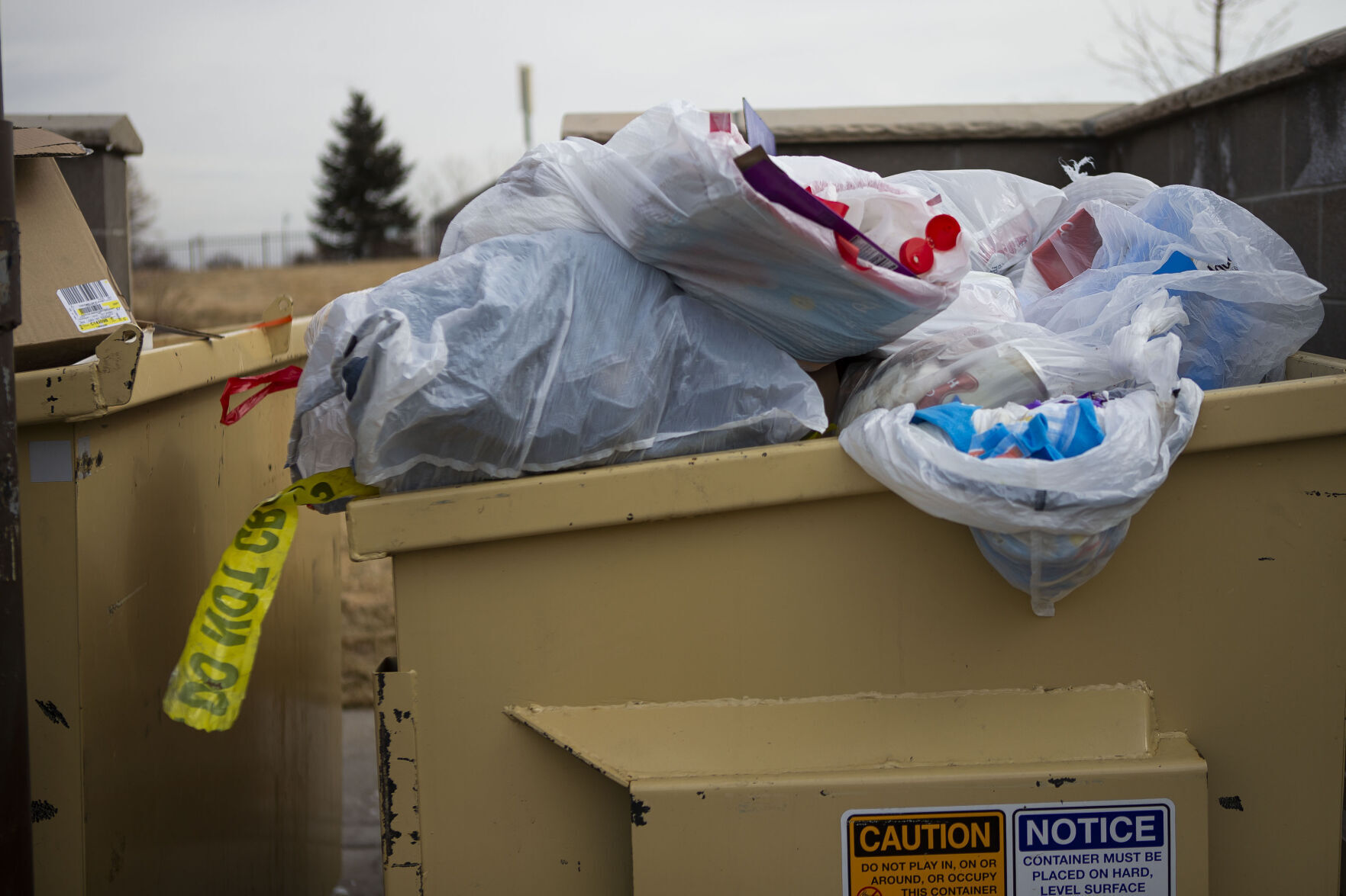 Police tape can be seen in the dumpster near an apartment building at 14480 East 104th Avenue where five people were found dead Sunday night, as seen on Monday, Feb. 21, 2022, in Commerce City, Colo. (Timothy Hurst/The Denver Gazette) (Timothy Hurst)