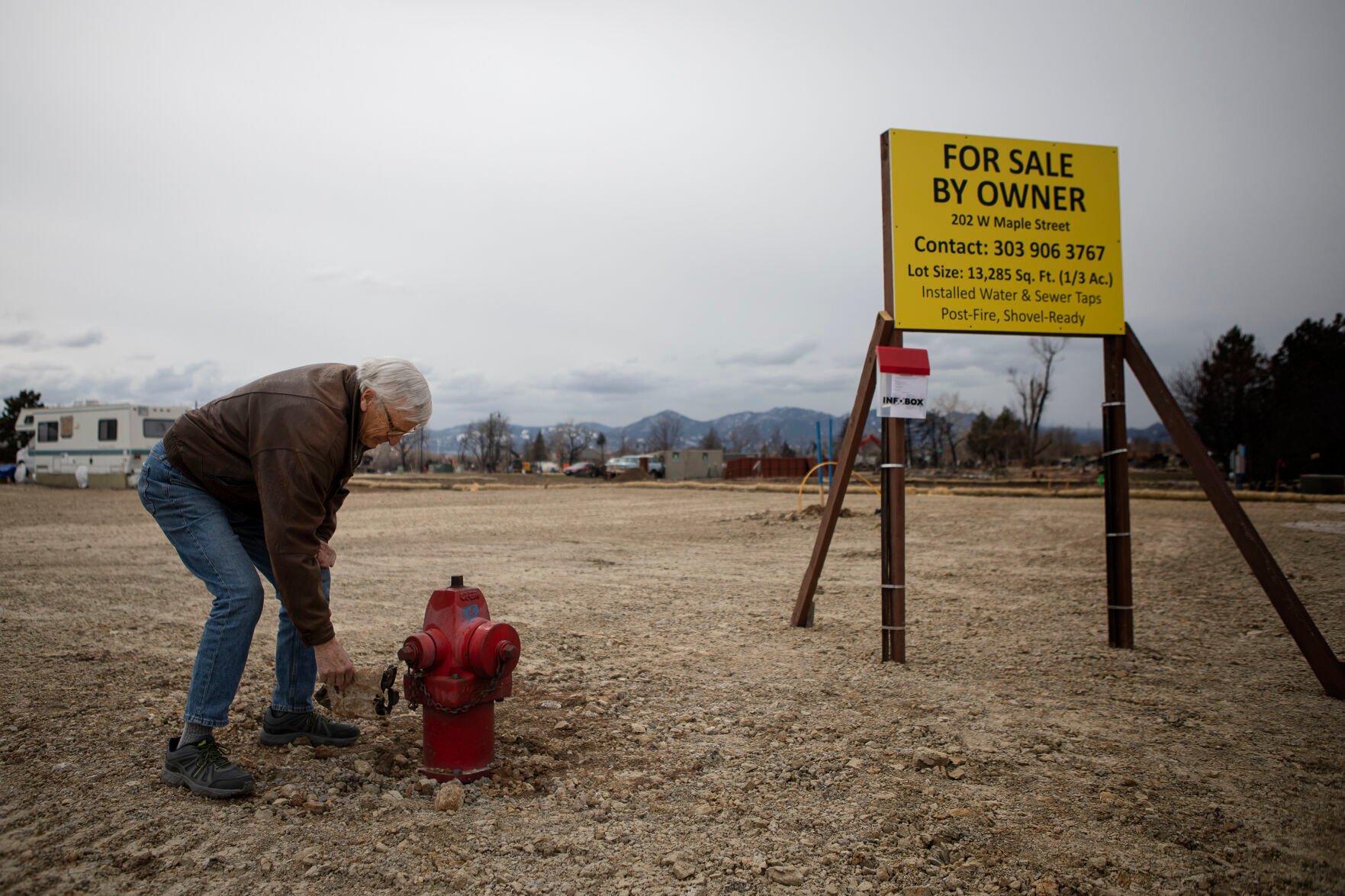 Superior resident Paul Williamson picks a piece of debris out of the dirt by a fire hydrant at his property in the Original Town neighborhood on Wednesday, March 16, 2022, in Superior, Colo. Williamson was quick to pull the debris out of the dirt, as he was worried that anything left on the property would be cause for failing an inspection. (Timothy Hurst/The Denver Gazette) (Timothy Hurst)