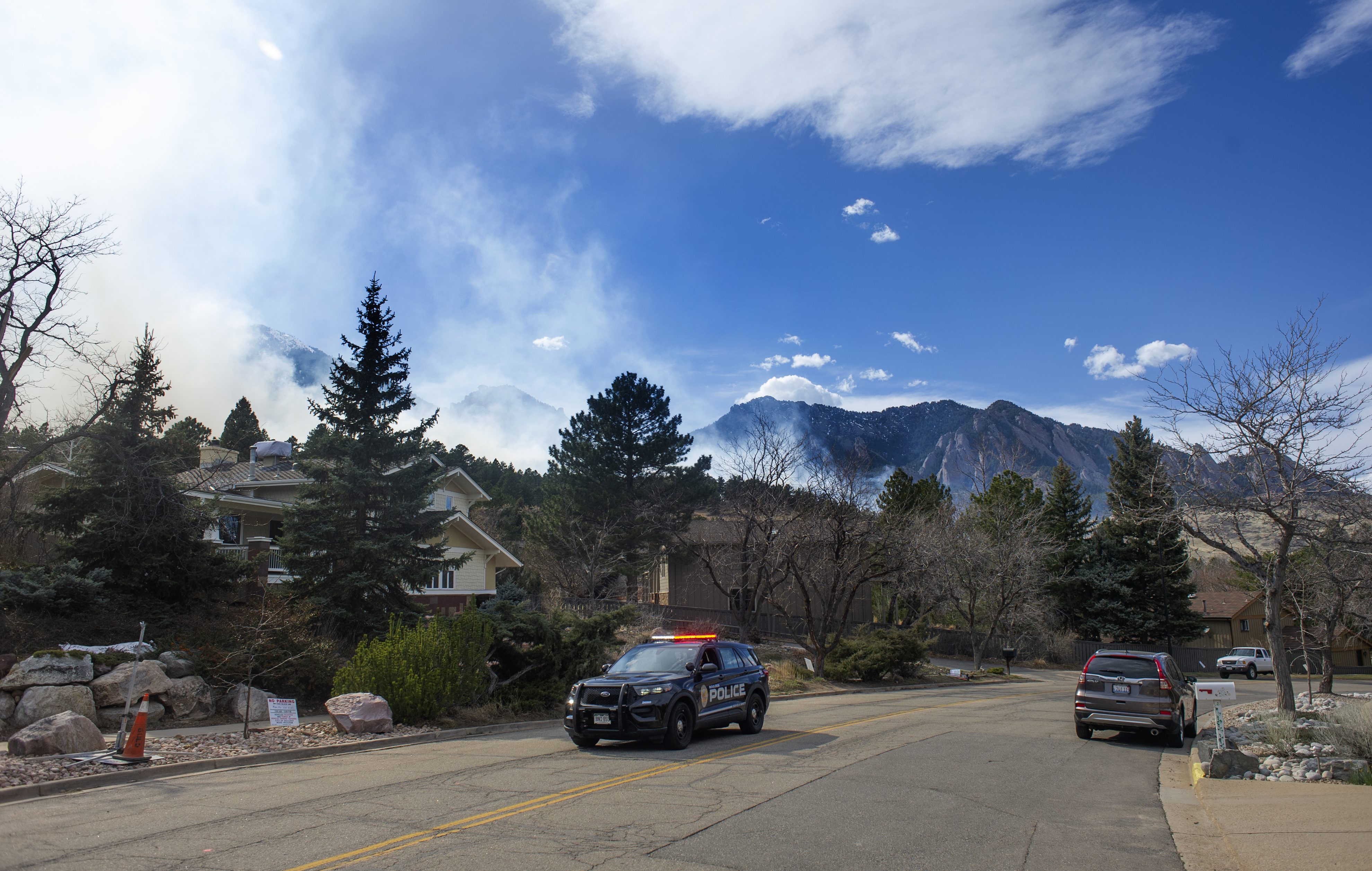 A police vehicle drives through an evacuation zone in south Boulder as smoke from the NCAR Fire obscures Bear Peak, on March 26, 2022, in Boulder, Colo. (Jacob Byk/For The Denver Gazette)
