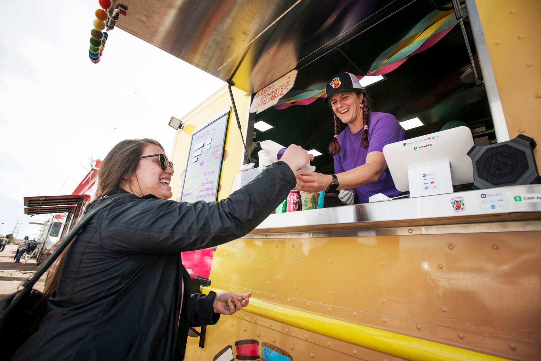 Lori Morrissey serves customer Shayna Blust a sweet treat from her food truck, Lori Lynn’s Cookies & Cream, during the 719 Food Truck Fest near Woodman Road in northeast Colorado Springs on Saturday, March 26, 2022. Morrissey features made-to-order ice cream sandwiches with her cookie made-from-scratch family recipes. (Chancey Bush/ The Gazette) (Chancey Bush/ The Gazette)