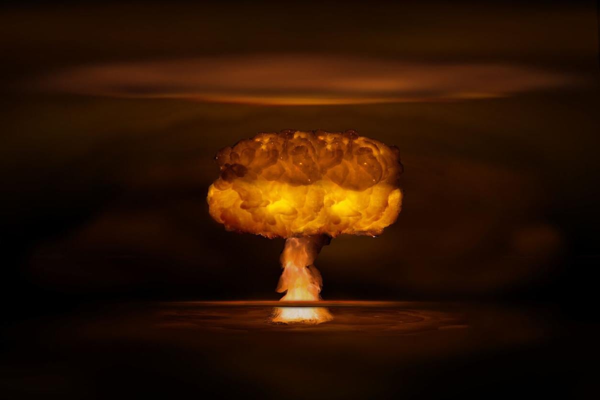 Atomic bomb realistic explosion, orange color with smoke on black background