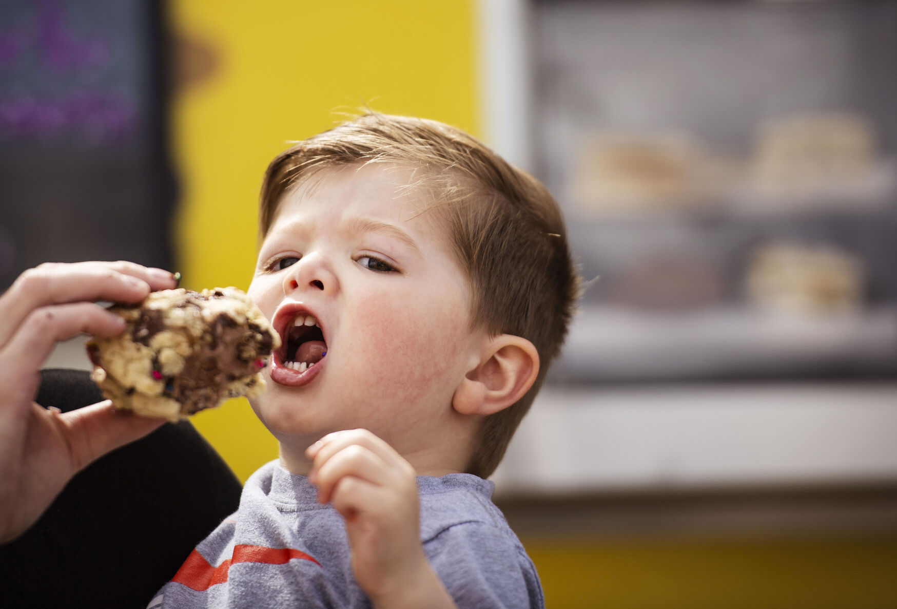 Jaxson Winderbaum, 2, enjoys a cookie ice cream sandwich at Lori Lynn’s Cookies & Cream food truck. (Chancey Bush/ The Gazette)