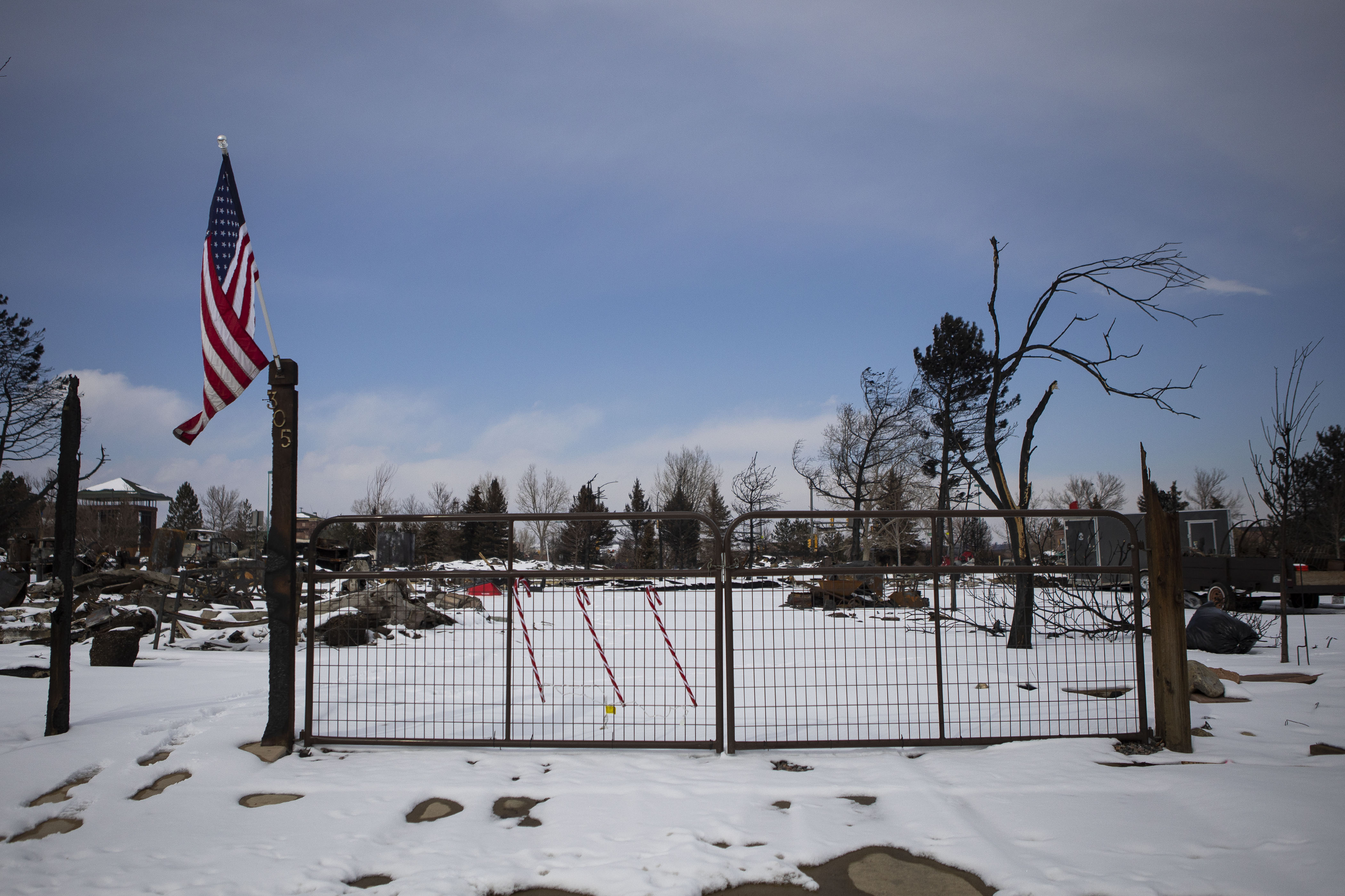 An American flag hangs at the gate to a property in the “Original Superior” neighborhood that was largely destroyed by the Marshall Fire, as seen on Friday, Feb. 25, 2022, in Superior, Colo. (Timothy Hurst/The Denver Gazette) (Timothy Hurst)