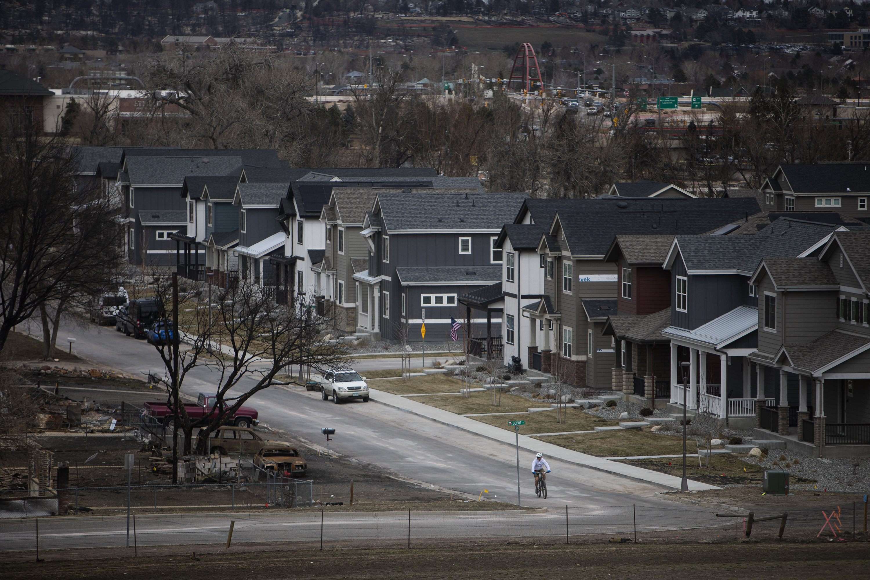A cyclist turns onto Depot Street, where homes on west side of the street were destroyed from the Marshall fire last December, as seen in the Original Town neighborhood on March 16 in Superior, Colo. (Timothy Hurst, The Denver Gazette)