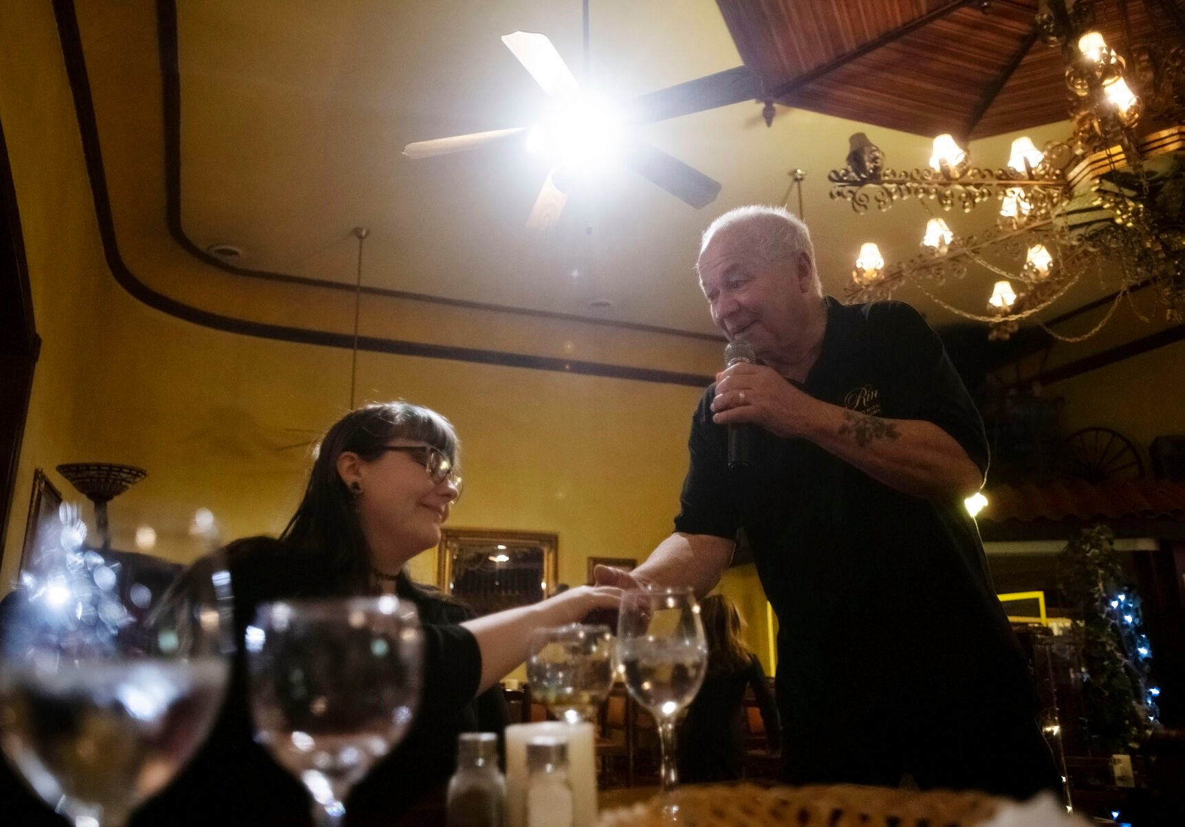Frank Cordova, 78, owner of Rino’s Italian Restaurant and Steakhouse, holds Skylar Taylor’s hand as he sings for his guests at his restaurant in Trinidad, Colorado., on Feb. 23, 2022. Taylor was celebrating her 23rd birthday and drove up from Albuquerque with her mother Tara Taylor to celebrate at Rino’s. Cordova and his brother Bob spent over 20 years in Las Vegas in the music industry and are known as the “original singing waiters” of Las Vegas. In 2002 they brought a sprinkle of Las Vegas back to their hometown of Trinidad and Frank continues to perform musical performers for his guests. (Chancey Bush /The Gazette) (Chancey Bush/ The Gazette)
