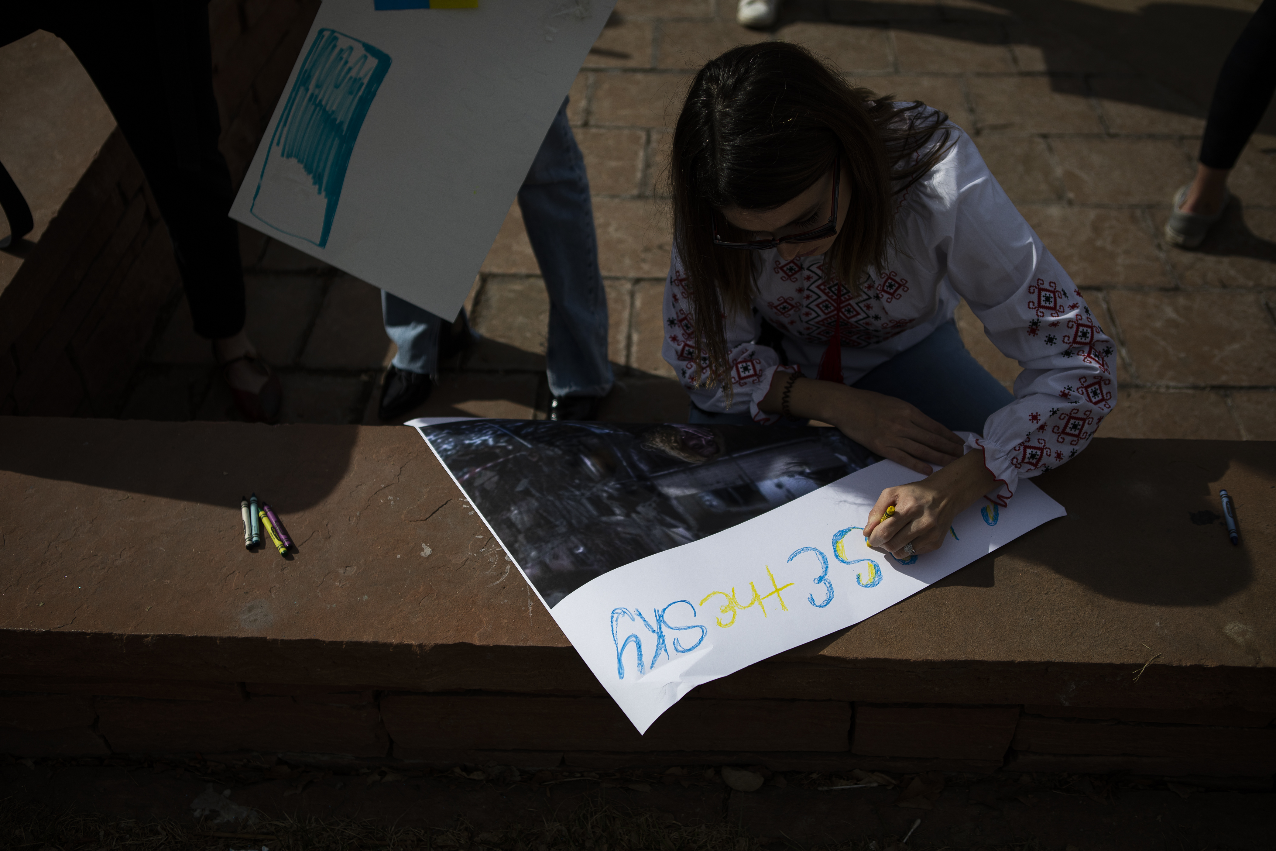 Ukrainian Inna Beliaeva writes “CLOSE THE SKY” over an image of an injured woman in Ukraine, during a protest outside the Colorado State Capitol in support of Ukraine on Wednesday, March 2, 2022, in Denver, Colo. The protest, organized by Nataliia Bondarchuk through Ukrainians of Colorado, is requesting that the skies over Ukraine be sheltered, help the Ukrainian military with troops, and sending ammunition and financial help to Ukraine. (Timothy Hurst/The Denver Gazette) (Timothy Hurst)