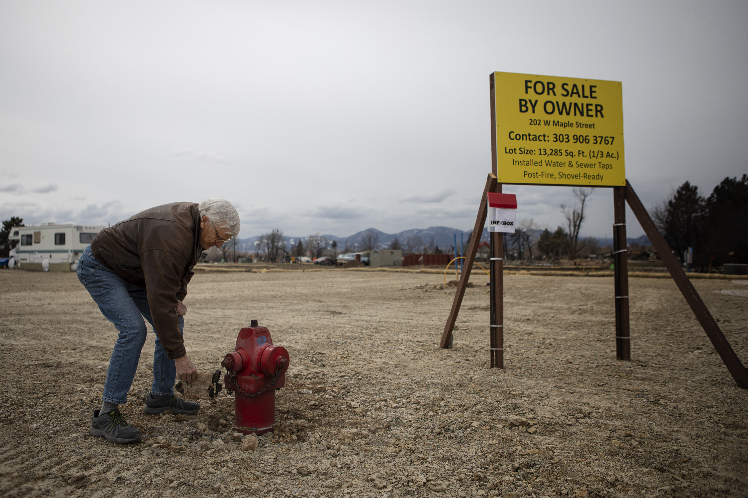 Superior resident Paul Williamson picks a piece of debris out of the dirt by a fire hydrant at his property in the Original Town neighborhood on Wednesday, March 16, 2022, in Superior, Colo. Williamson was quick to pull the debris out of the dirt, as he was worried that anything left on the property would be cause for failing an inspection. (Timothy Hurst/The Denver Gazette) (Timothy Hurst)