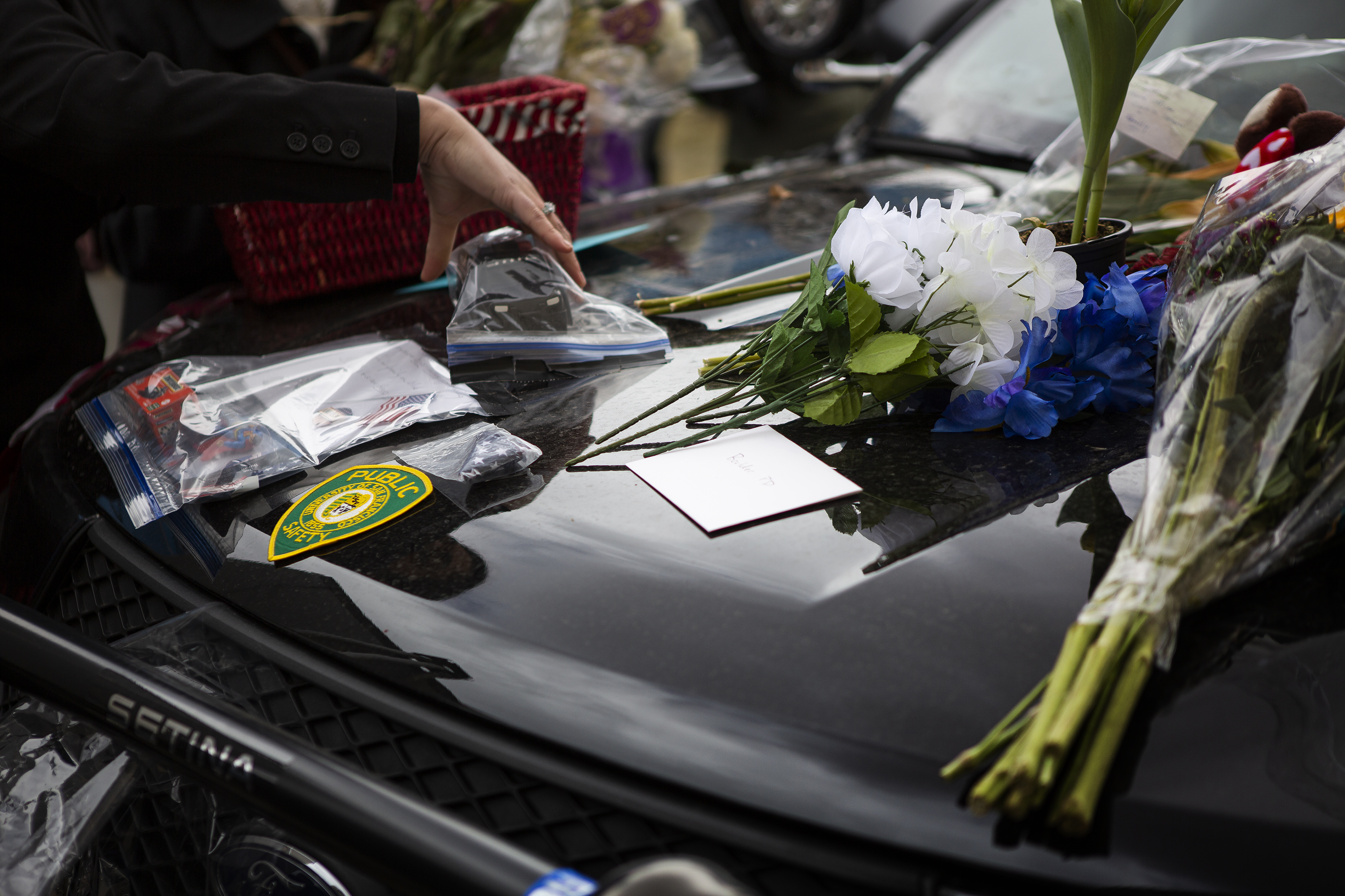 The family of slain Boulder Police officer Eric Talley collect the flowers and other item left on a police cruiser outside the department after a Line of Duty Death commemoration for officer Eric Talley at the Boulder Police Department on Tuesday, March 22, 2022, in Boulder, Colo. (Timothy Hurst/The Denver Gazette) (Timothy Hurst)