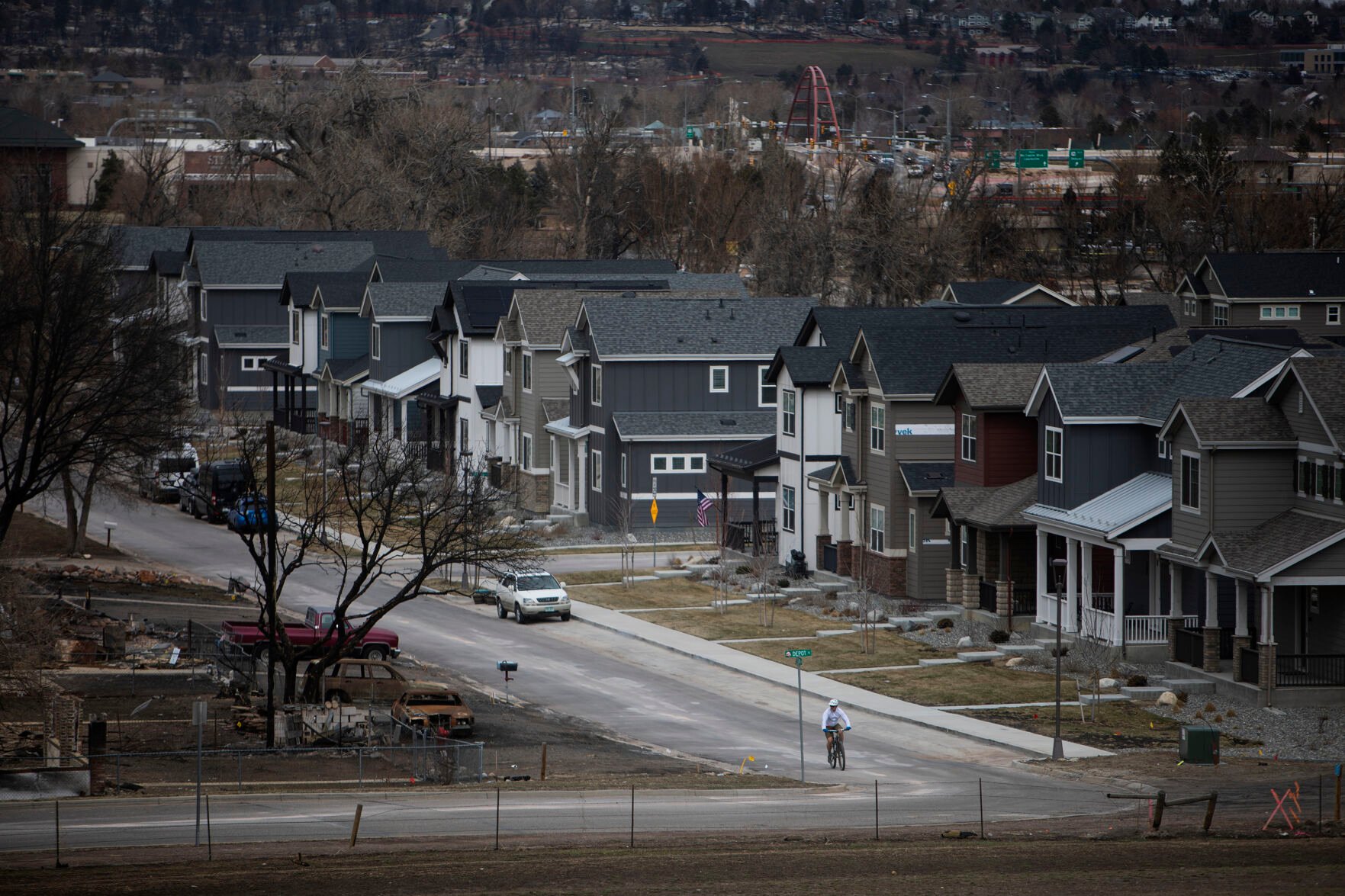 A cyclist turns onto Depot Street, where homes on west side of the street were destroyed from the Marshall Fire last December, as seen in the Original Town neighborhood on Wednesday, March 16, 2022, in Superior, Colo. (Timothy Hurst/The Denver Gazette) (Timothy Hurst)