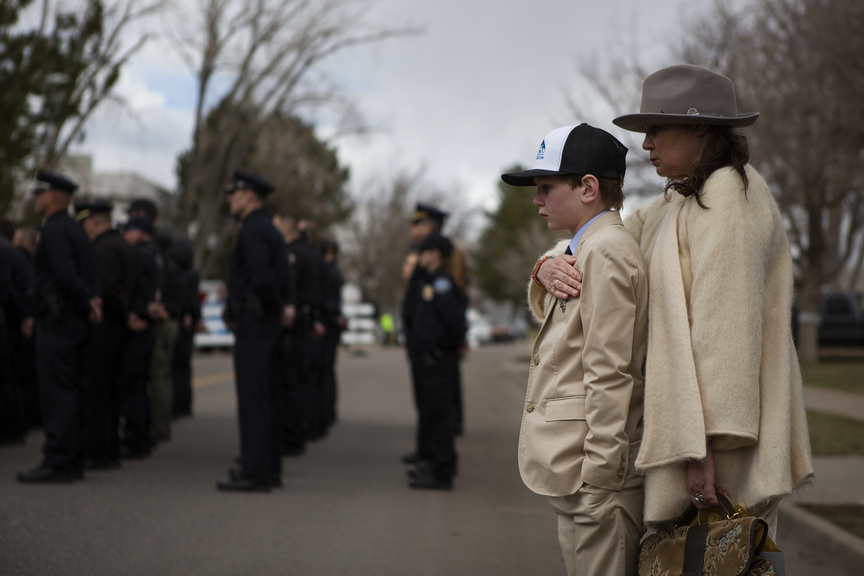 Susan Gilmore wraps a hand around her son Gil Gilmore, 10, during a Line of Duty Death commemoration for officer Eric Talley at the Boulder Police Department on Tuesday, March 22, 2022, in Boulder, Colo. (Timothy Hurst/The Denver Gazette) (Timothy Hurst)