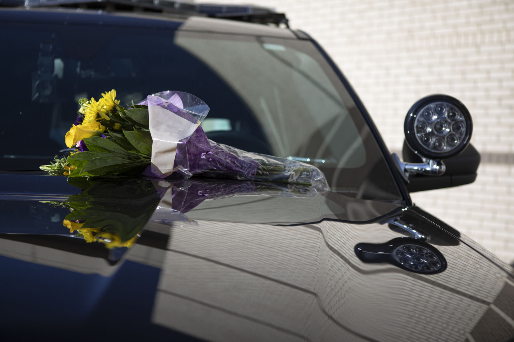 Flowers set on the hood of a police cruiser outside the department by Boulder police officer Brian Rech can be seen at the memorial set up for slain officer Eric Talley, who was killed nearly a year ago while responding to the mass shooting at the King Soopers on Table Mesa Drive, on Friday, March 18, 2022, in Boulder, Colo. (Timothy Hurst/The Denver Gazette) (Timothy Hurst)
