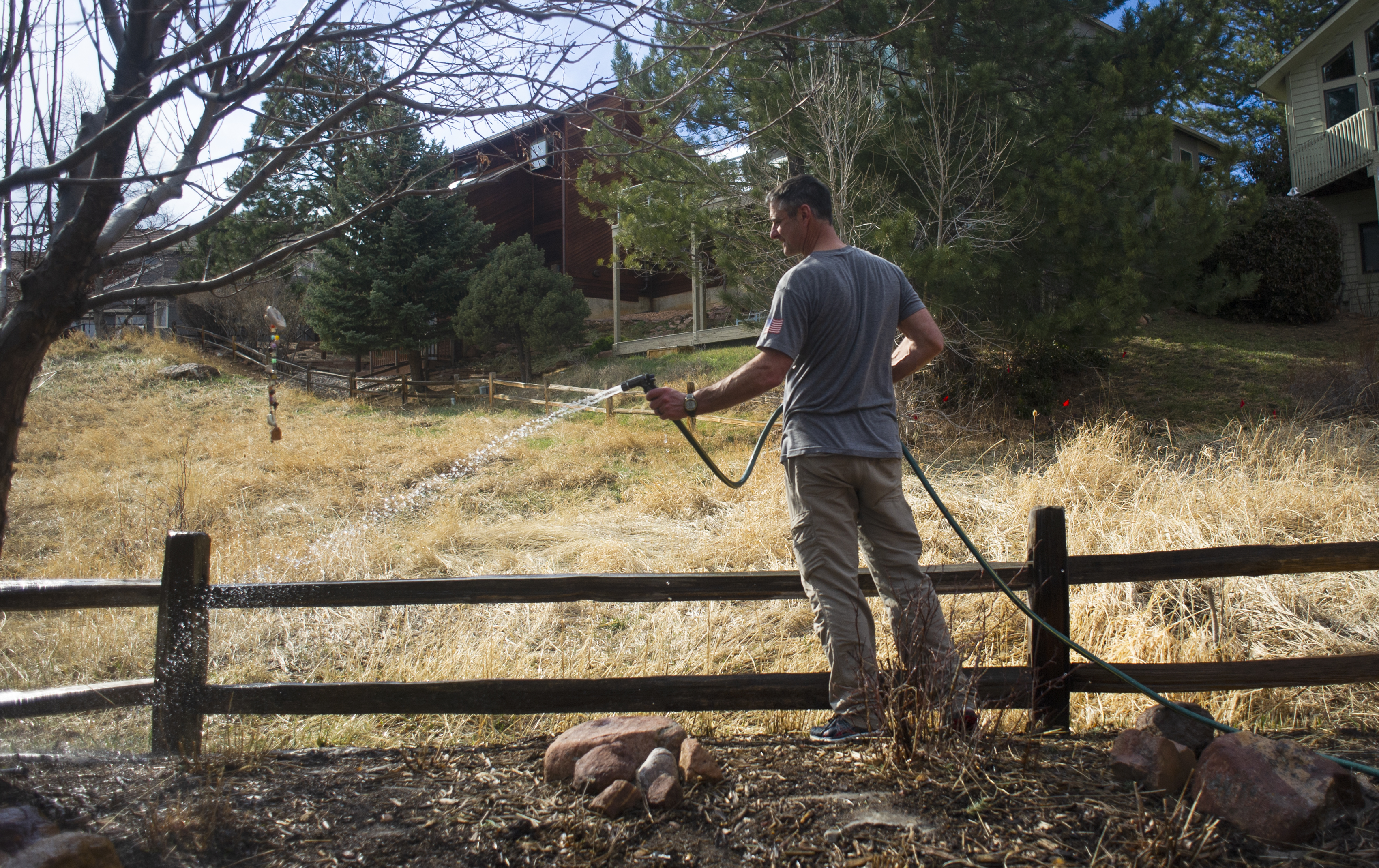 Brad James, a homeowner in the Shanahan Ridge neighborhood of south Boulder, waters the outside before evacuating due to the NCAR Fire on March 26, 2022, in Boulder, Colo. (Jacob Byk/For The Denver Gazette)