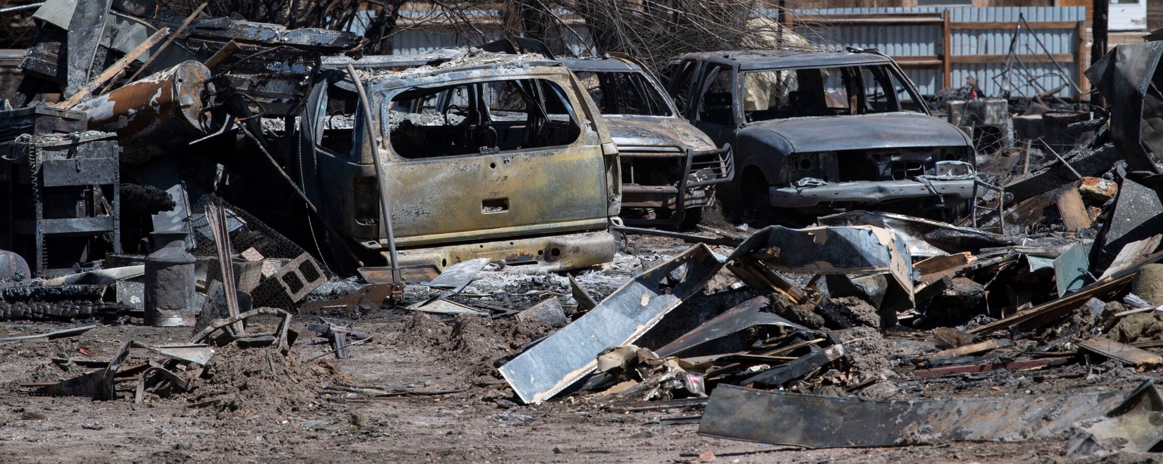 The burned remains of vehicles stand in the backyard of a home on Newcomb Street in Monte Vista on Friday, after a fire fueled by high winds Wednesday burned 17 structures and displaced six families. (Christian Murdock, The Gazette)