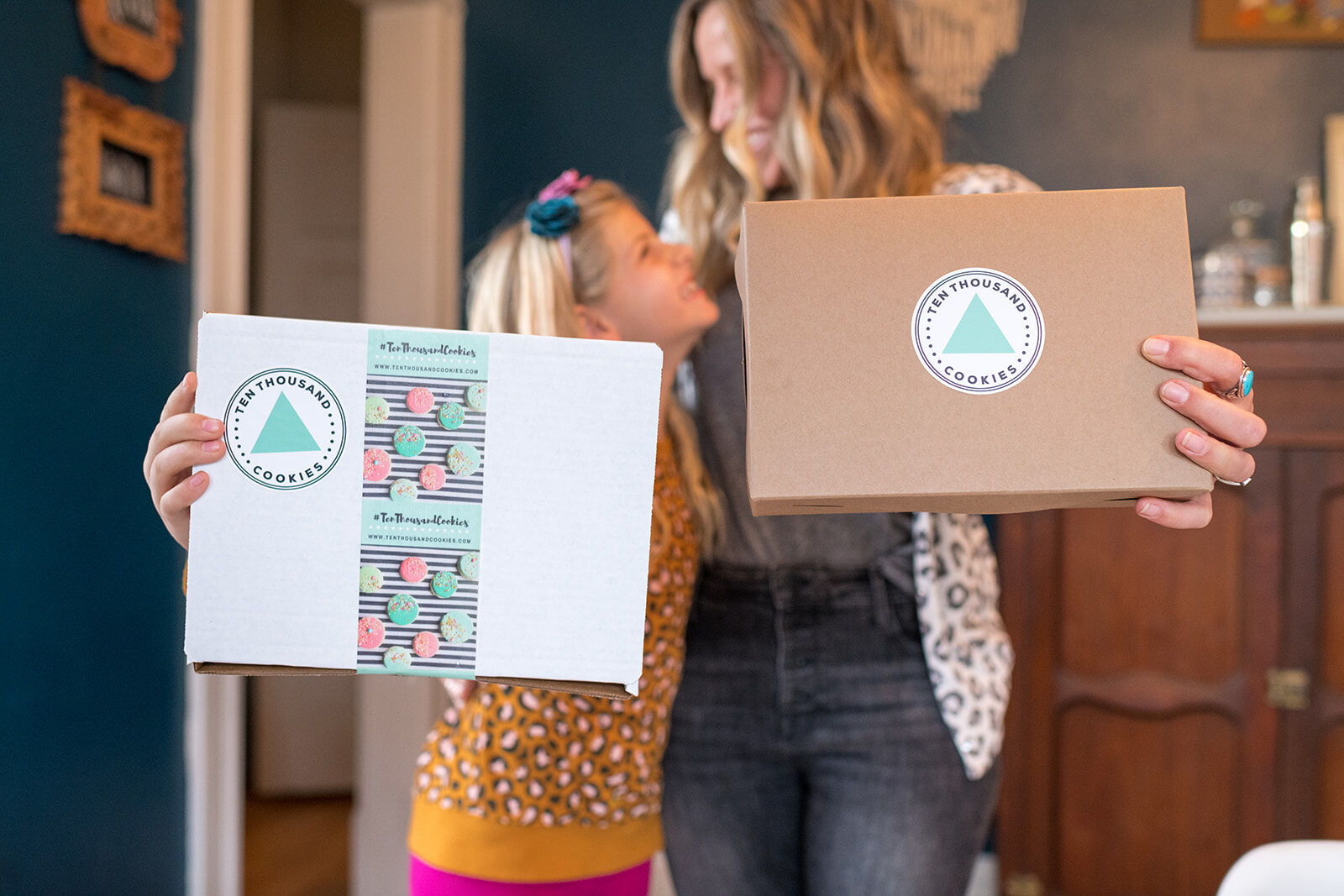 Ashley Greeno stands with her daughter, Lily, with boxes used to ship cookies to customers. (Courtesy of Xaris Photography)