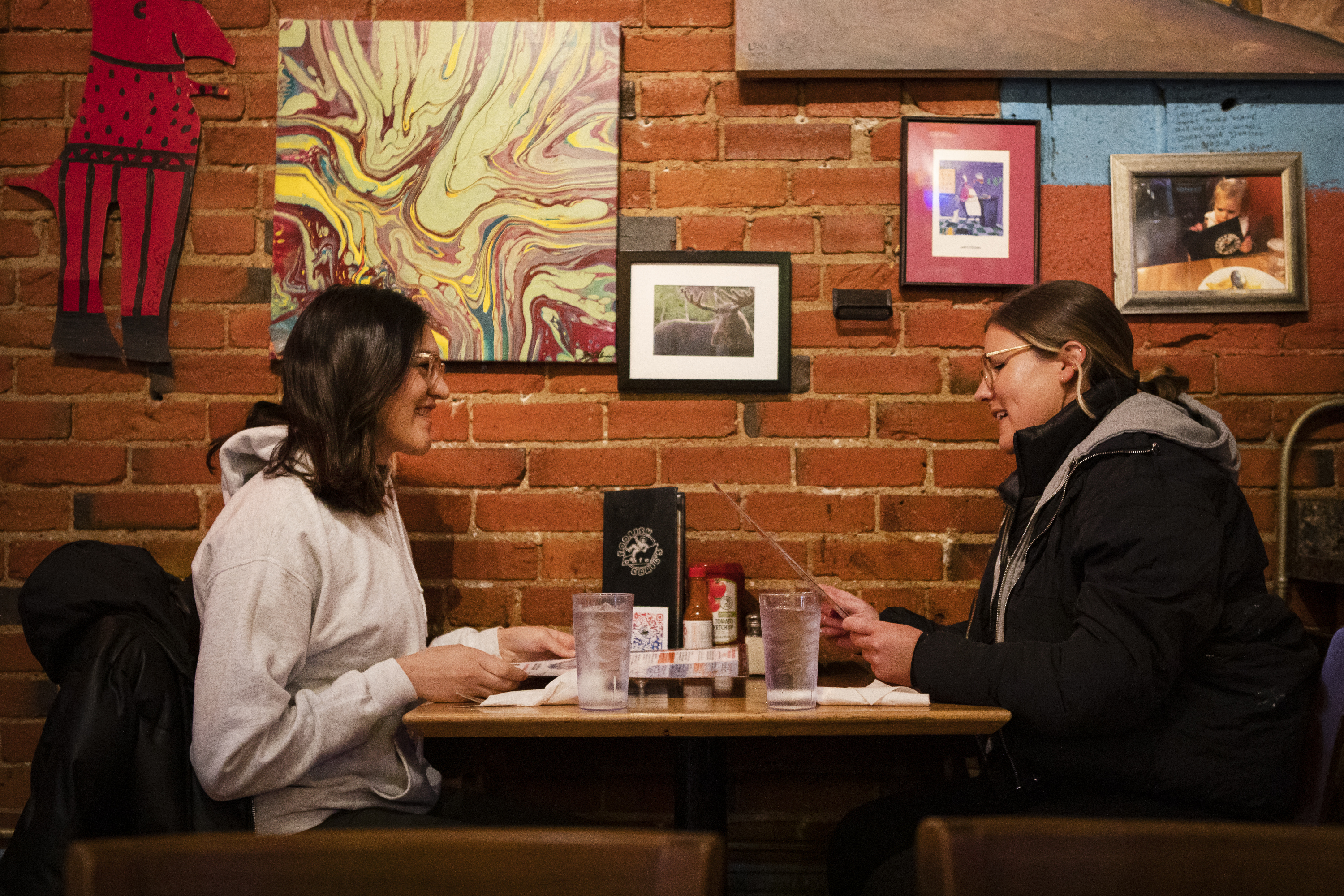Romi Quiroga, left, and Hayley Morgan look over the menu while grabbing lunch for Quiroga’s birthday on Wednesday, April 13, 2022, at Foolish Craig’s Cafe in Boulder, Colo. (Timothy Hurst/The Denver Gazette) (Timothy Hurst)