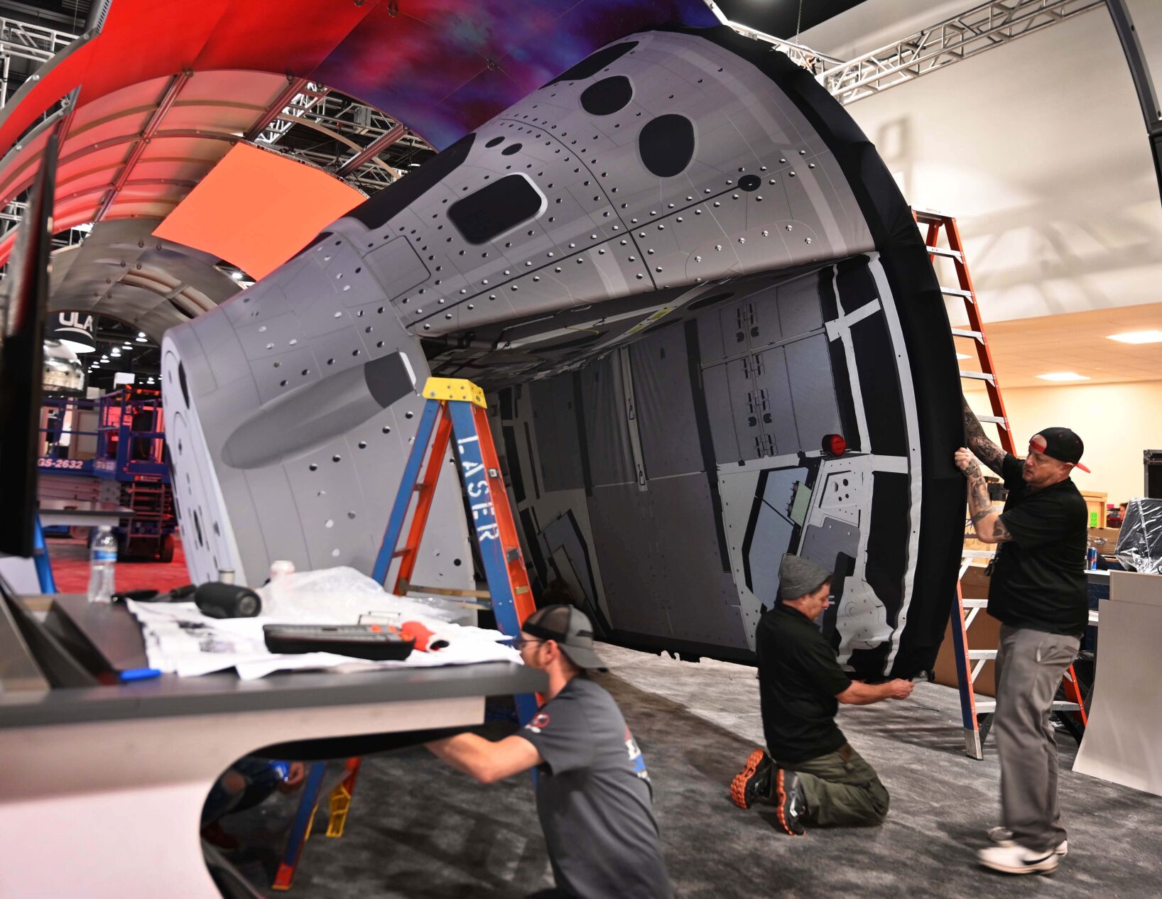 There was a beehive of activity going on at the Broadmoor as crews were getting ready for the start of the 37th Space Symposium which starts late Monday. A lighter mockup version of the Orion Space Capsule is lifted into place at the Lockheed Martin display on Sunday, April 3, 2022. The capsule is part of the Artemis Mission, a space mission run by NASA with the goal of landing astronauts on the moon for the first time since 1972. (Photo by Jerilee Bennett, The Gazette) (Jerilee Bennett)