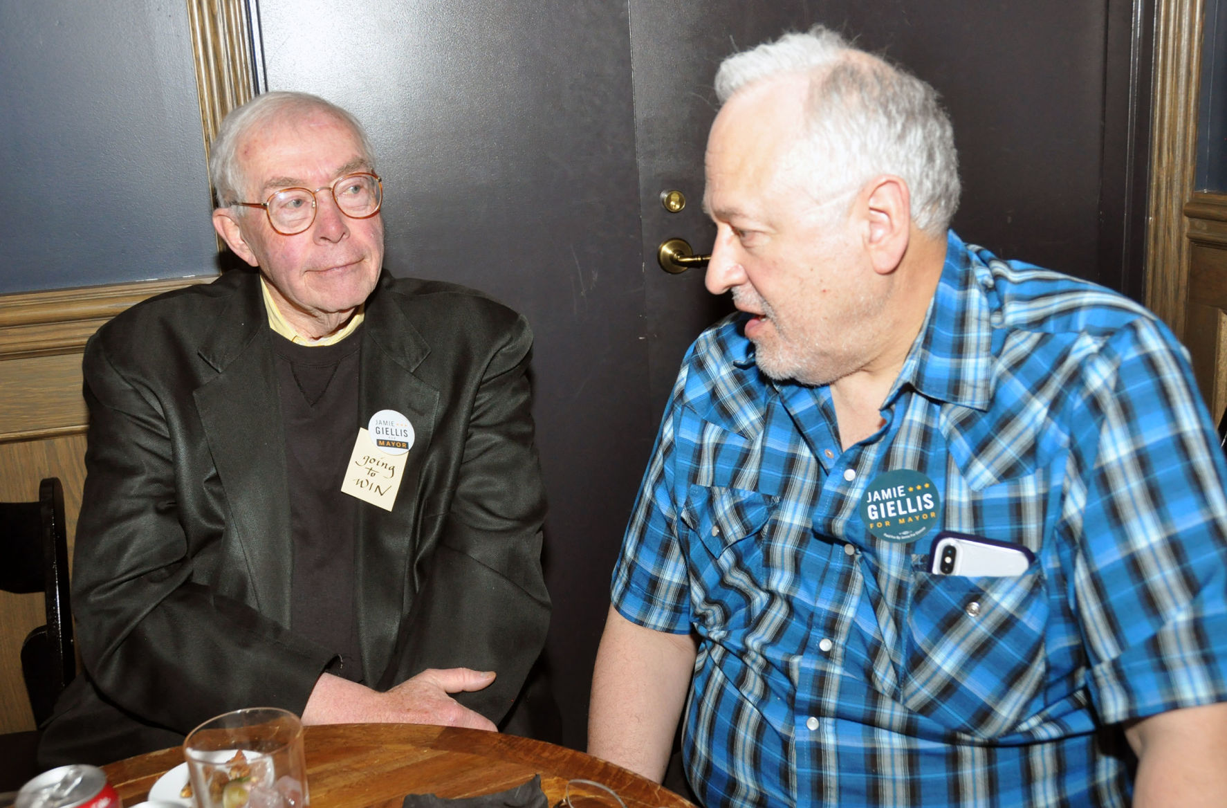 Mayoral candidate Jamie Giellis supporters Dennis Gallagher and Rob Hernandez, both former Democratic state senators from Denver, discuss the impending run-off between Giellis and two-term Denver Mayor Michael Hancock on Tuesday, May 7, 2019, at the Ramble Hotel in Denver's Upper Larimer Neighborhood. ((Ernest Luning/Colorado Politics))
