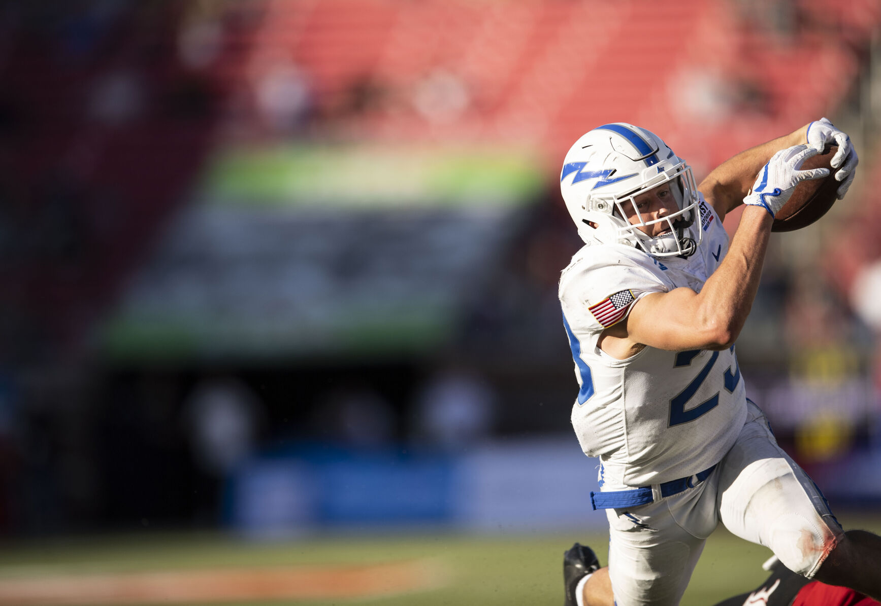 Air Force sophomore Dane Kinamon (23) carries the ball as Louisville senior Qwynnterrio Cole (12) closes in for the tackle during the first half as the Air Force Falcons take on the Louisville Cardinals during the 2021 First Responder Bowl at Gerald J. Ford Stadium on the campus of Southern Methodist University in Dallas, Texas on Tuesday, Dec. 28, 2021. (Chancey Bush/ The Gazette) (Chancey Bush/ The Gazette)