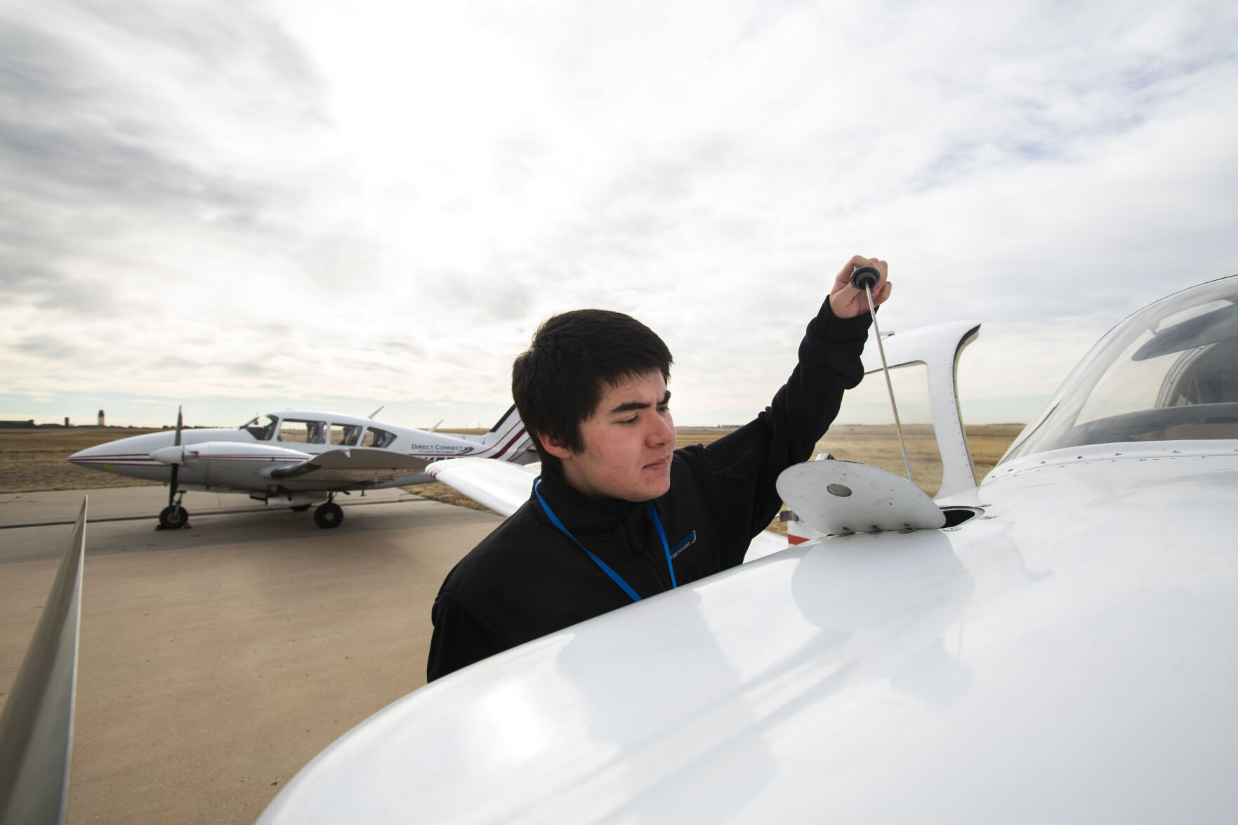 Freshman Nolan Shell checks the oil while performing a preflight check on a Piper airplane Monday, March 28, 2022, while taking classes at Direct Connect Flight Academy at the Colorado Springs Airport. The Metro State student has logged more than 60 hours of flight time and has earned his private pilot license since starting the aviation program in the fall. (The Gazette, Christian Murdock) (Christian Murdock/The Gazette)