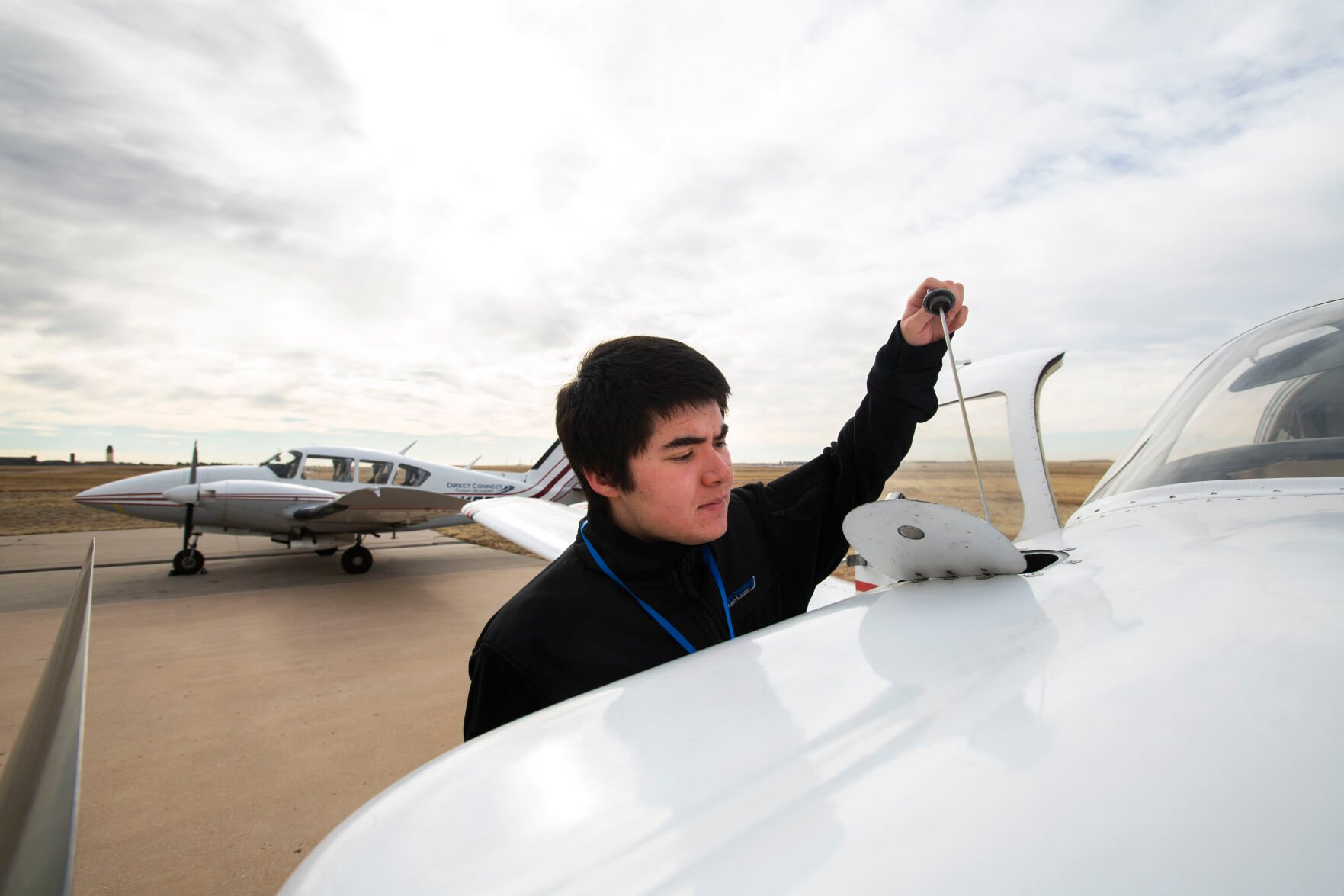 Freshman Nolan Shell checks the oil while performing a preflight check on a Piper airplane Monday, March 28, 2022, while taking classes at Direct Connect Flight Academy at the Colorado Springs Airport. The Metro State student has logged more than 60 hours of flight time and has earned his private pilot license since starting the aviation program in the fall. (The Gazette, Christian Murdock) (Christian Murdock/The Gazette)