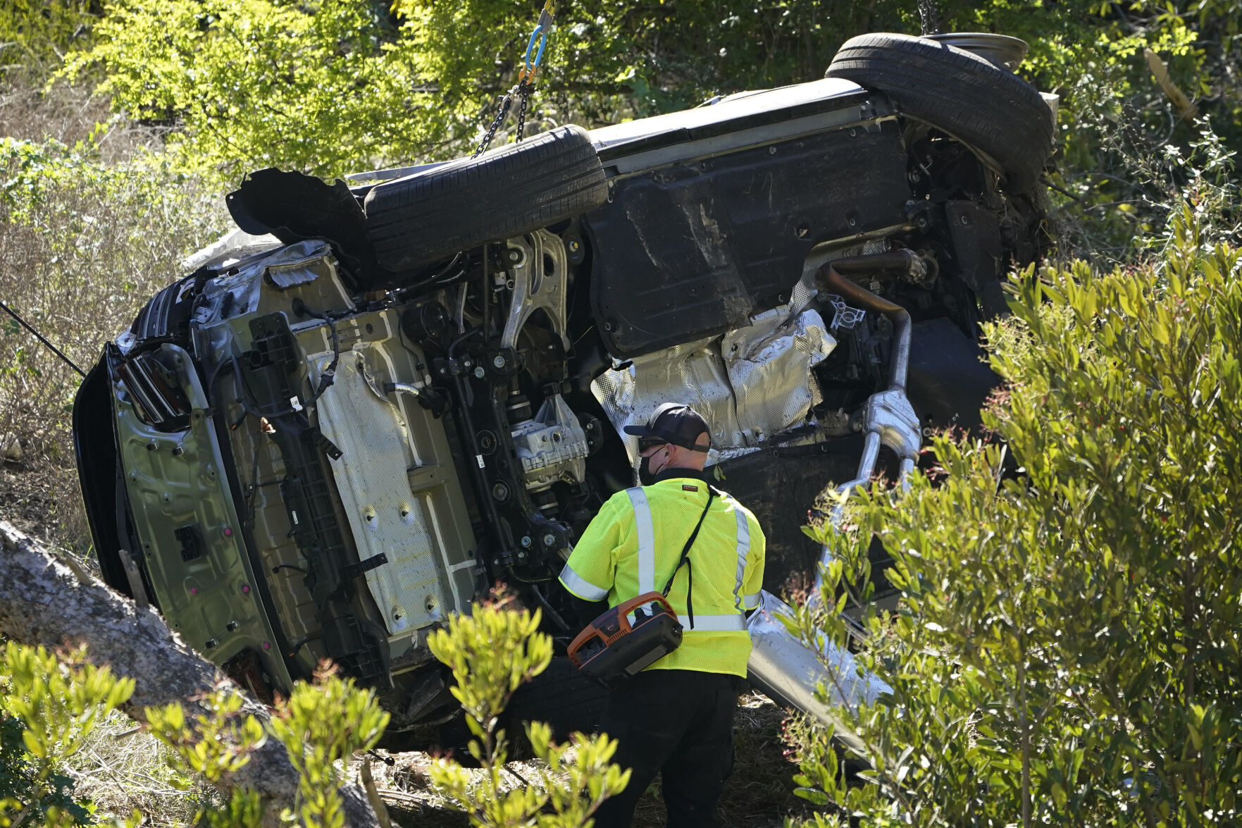 FILE - A vehicle rests on its side after a rollover accident involving golfer Tiger Woods Tuesday, Feb. 23, 2021, in Rancho Palos Verdes, Calif., a suburb of Los Angeles. Woods' injuries from the crash were so severe that doctors considered right leg amputation, before reassembling the limb by placing a rod in the tibia and using screws and pins to stabilize additional injuries in the ankle and foot. Woods says, for now anyway, he's planning to play this week in the Masters. The five-time champion at Augusta National made the announcement Tuesday morning, April 5, 2022. (AP Photo/Marcio Jose Sanchez, File) (Marcio Jose Sanchez)