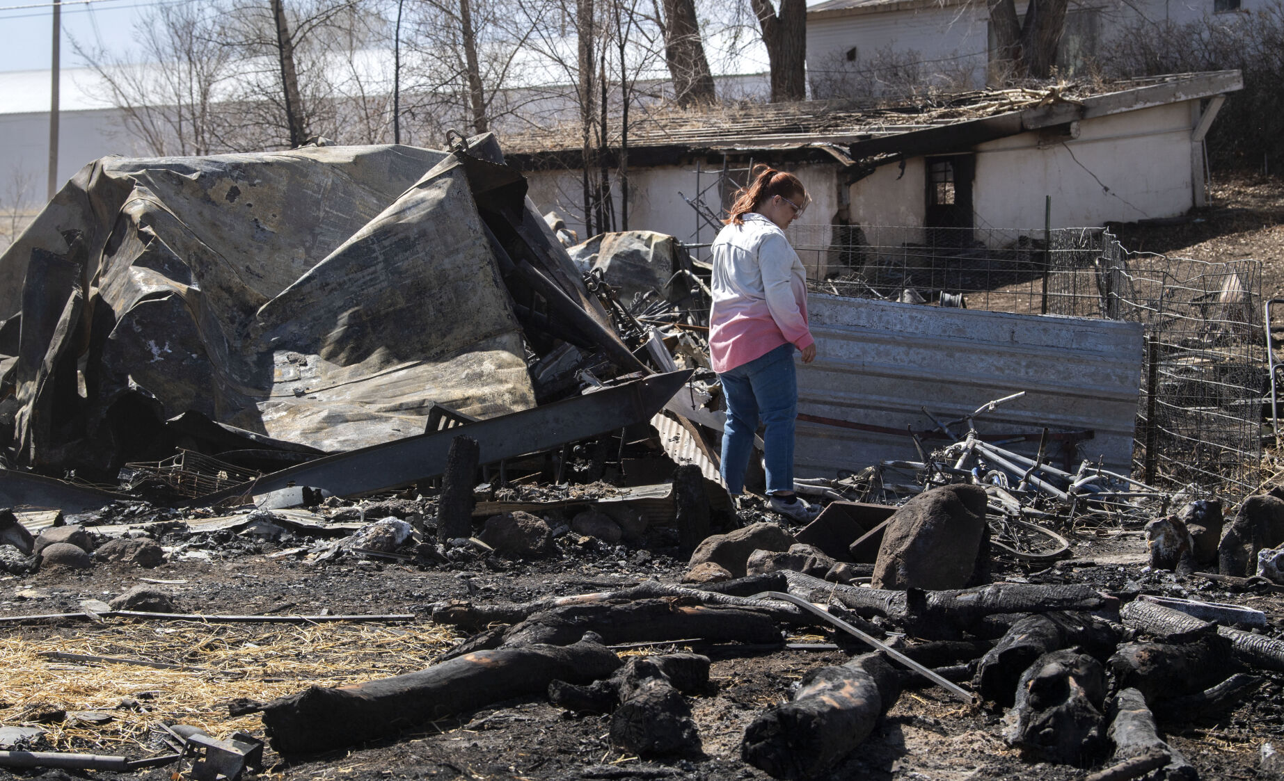 Chandra Campos searches through the remains of their home in Monte Vista on Friday. A fire fueled by high winds Wednesday burned 17 structures and displaced six families. Campos and her family lost most of their belongings. (Christian Murdock, The Gazette)