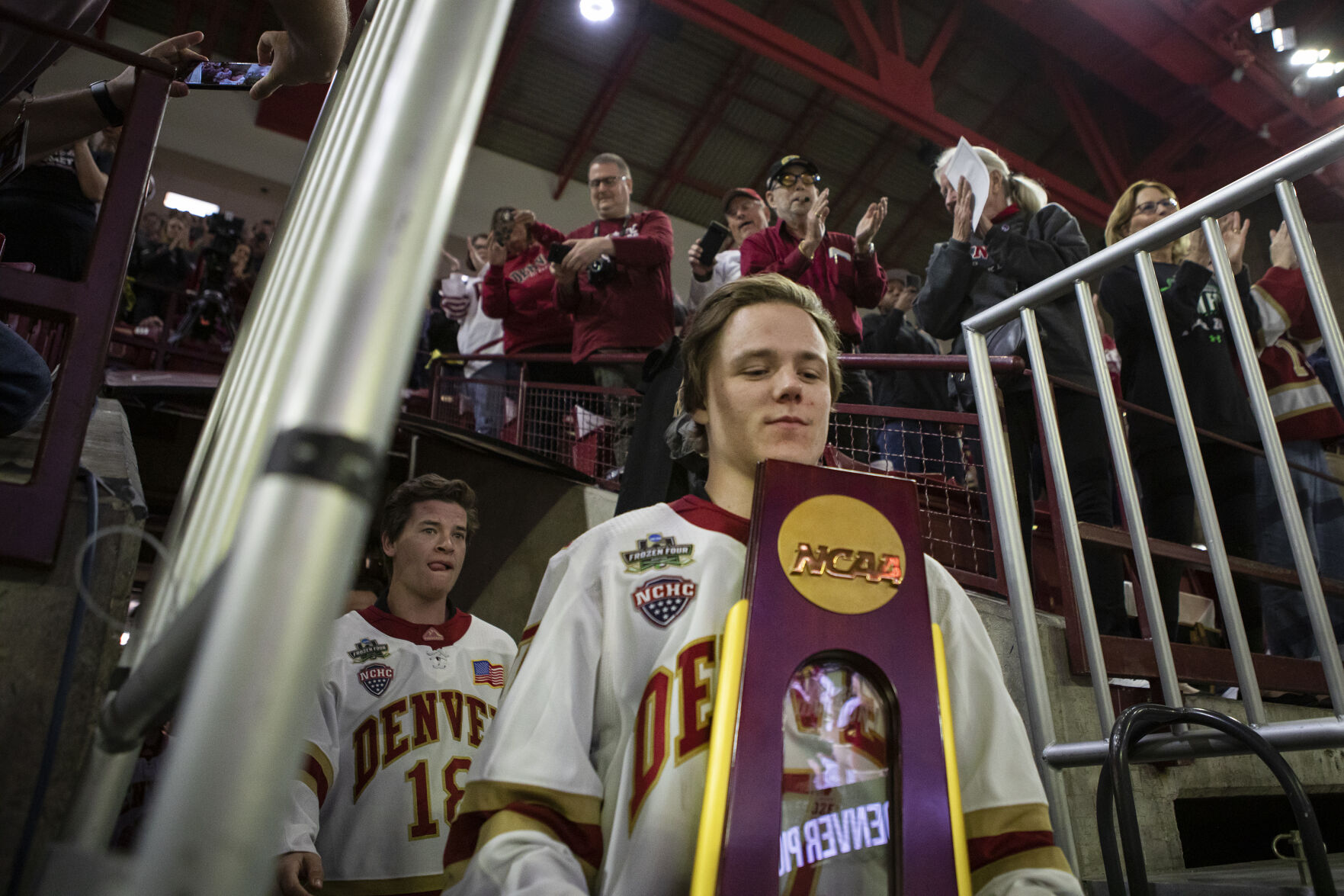 University of Denver senior forward Brett Stapley (7) carries the national championship trophy out to an erupting crowd during the 2022 National Championship Celebration on Tuesday, April 12, 2022, at Magness Arena in Denver, Colo. (Timothy Hurst/The Denver Gazette) (Timothy Hurst, The Denver Gazette)
