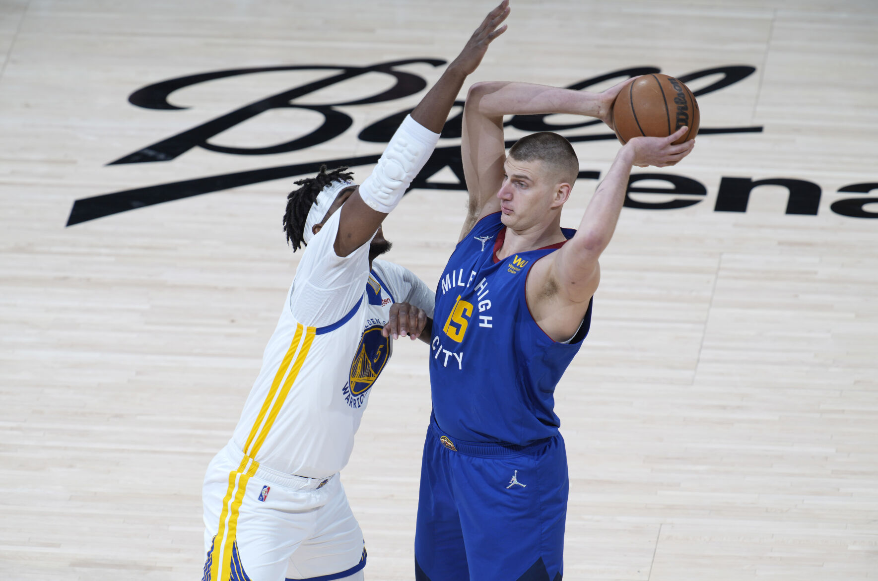 Denver Nuggets center Nikola Jokic, right, looks to pass the ball as Golden State Warriors center Kevon Looney defends in the first half of Game 3 of an NBA basketball first-round Western Conference playoff series Thursday, April 21, 2022, in Denver. (AP Photo/David Zalubowski) (The Associated Press)