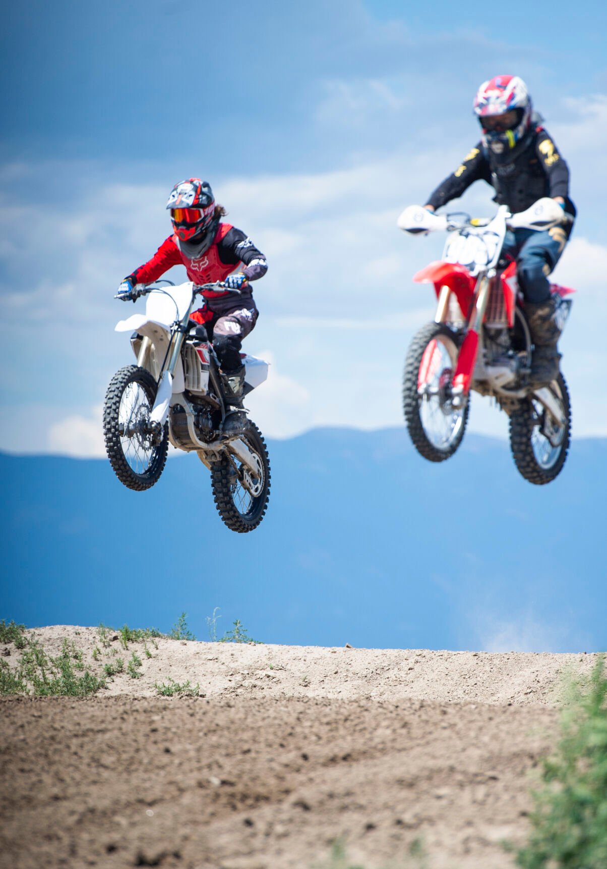 Racers hit a jump in unison during a Colorado Off-Road Championship Series race at RAM Of-Road Park in July 2019. (Parker Seibold)