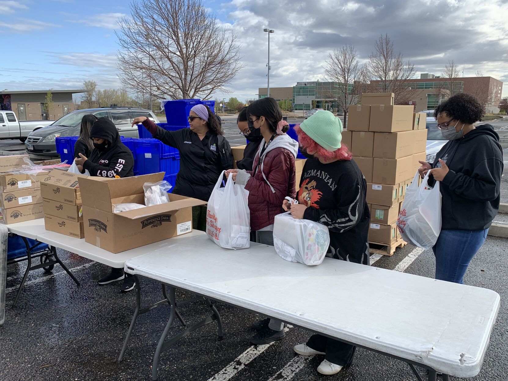 In this file photo, Jennifer Monsevais, who wears a gray headband, directs the volunteers students from the Denver Center for International Studies at Montbello and the Noel Community Arts School at Montbello at the Food Bank of the Rockies mobile food pantry at Montbello Recreation Center Thursday. They packed more than 150 bags of children’s meals. (DENNIS HUSPENI/THE DENVER GAZETTE)