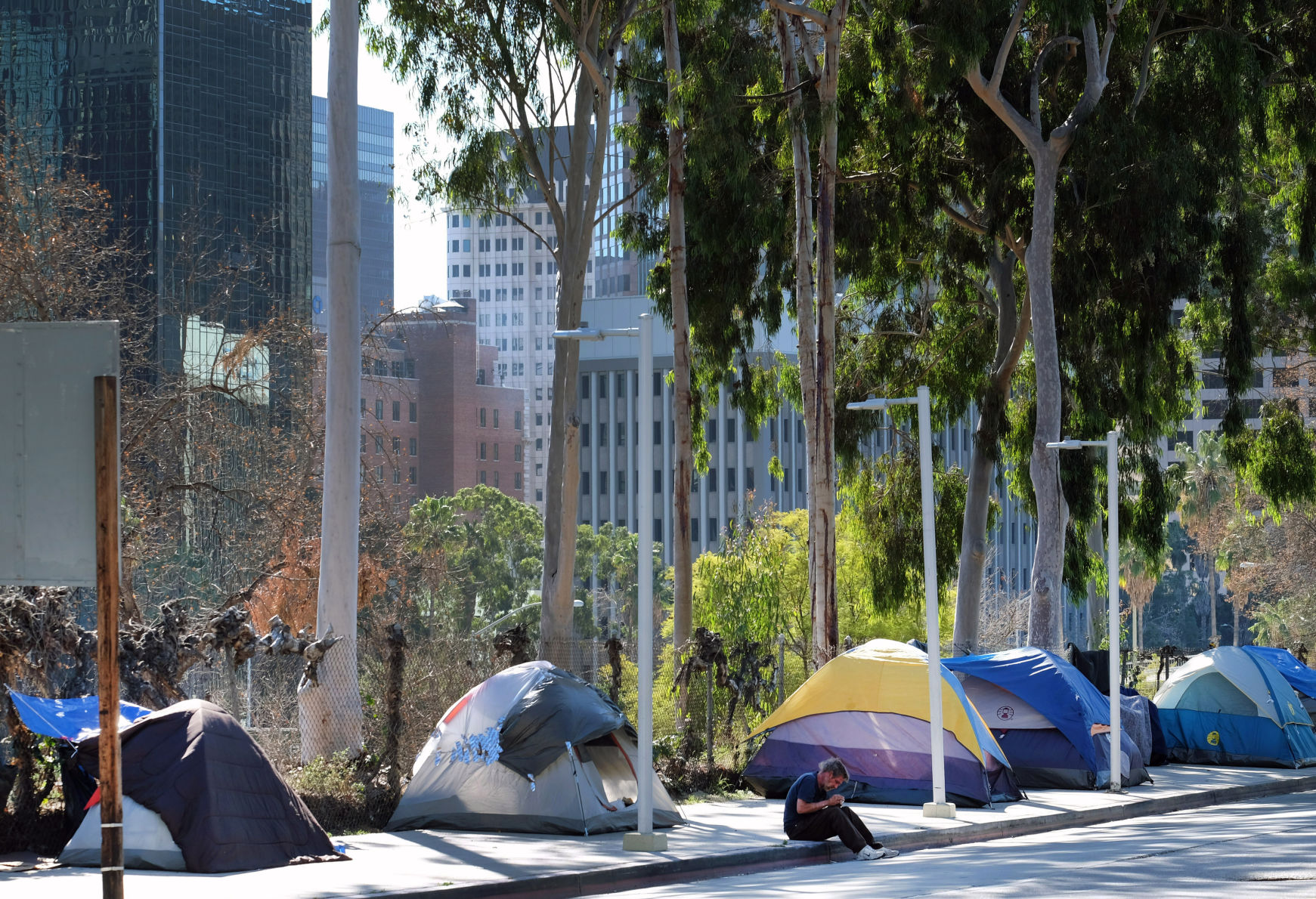 A homeless man sits by his tent on the street in downtown Los Angeles in this Associated Press file photo. (Richard Vogel)
