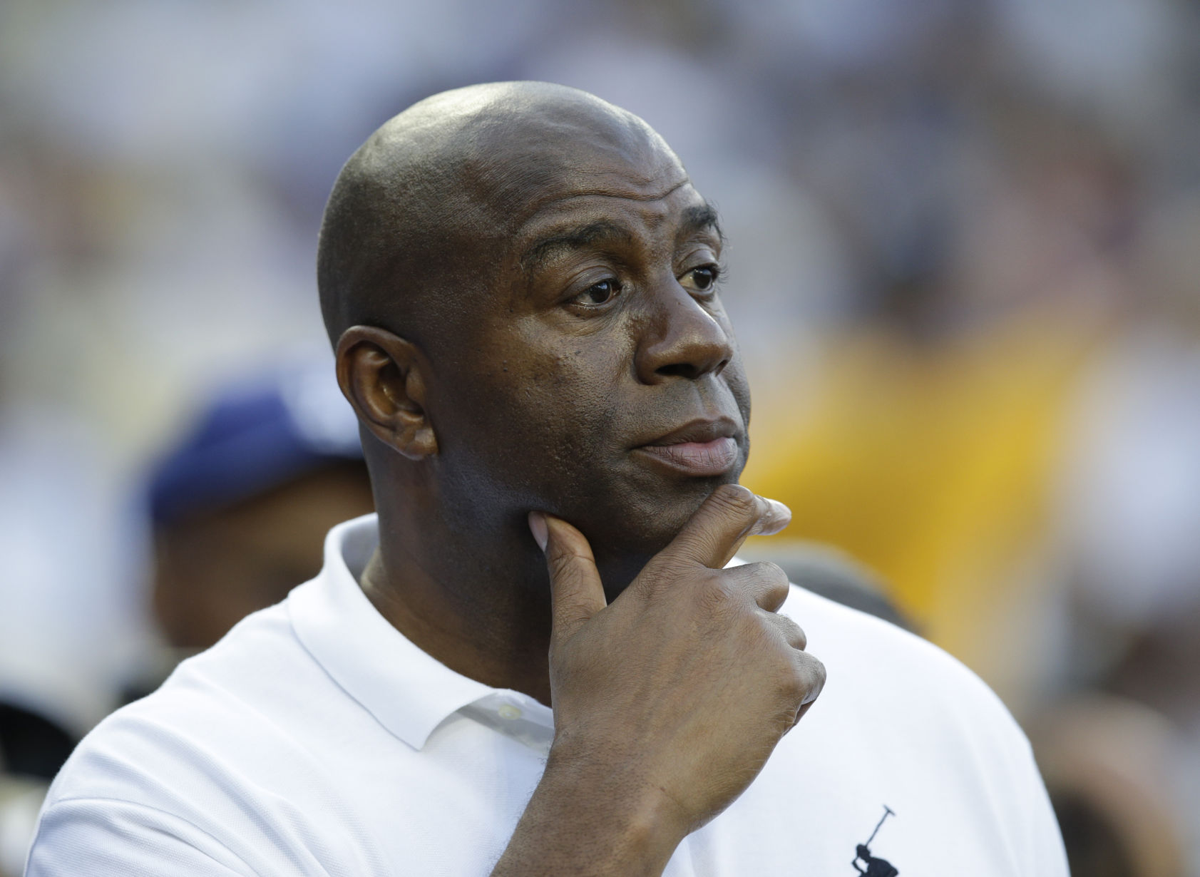 FILE - In this May 27, 2014, file photo, Magic Johnson watches before a baseball game between the Los Angeles Dodgers and Cincinnati Reds in Los Angeles. Magic Johnson says he's pleased pro athletes are supporting peaceful protests around the nation by using 