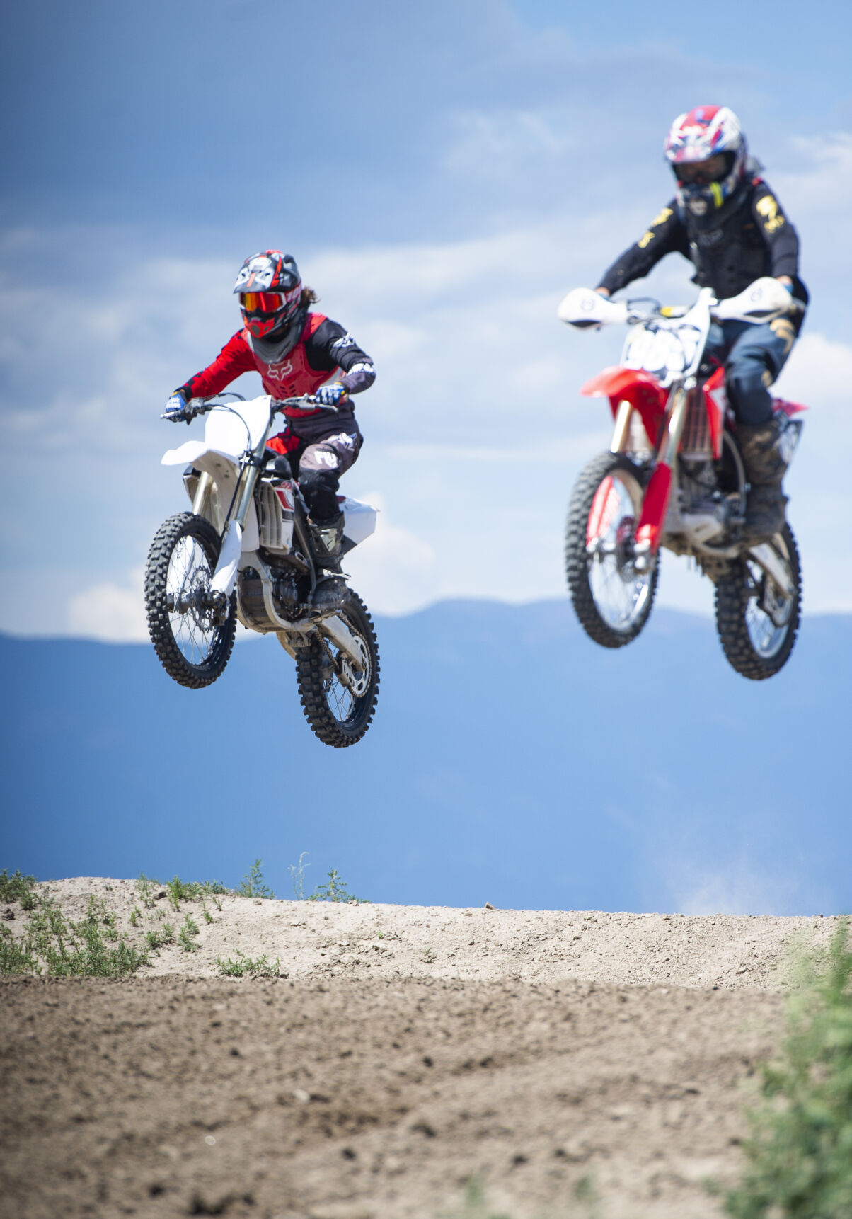 Racers hit a jump in unison during a Colorado Off-Road Championship Series race at RAM Of-Road Park in July 2019. (Parker Seibold)