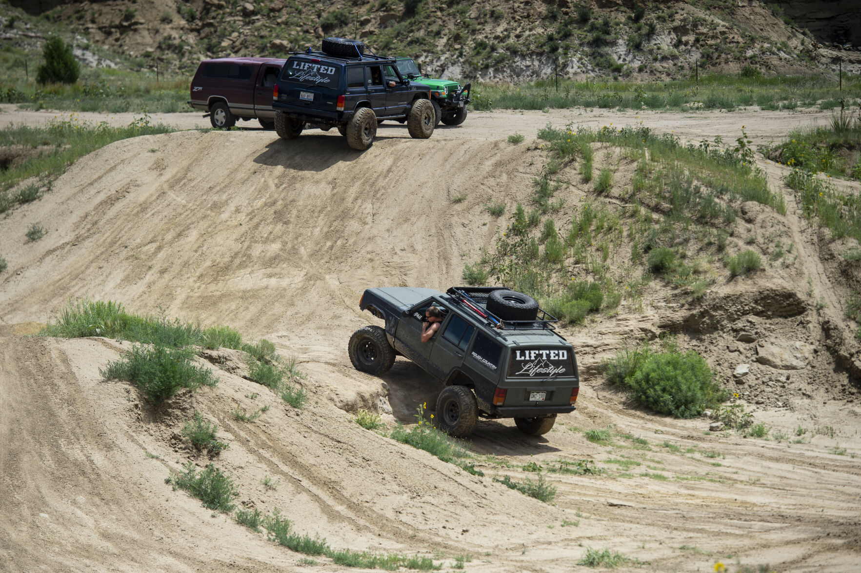 A driver looks out of their window as they drive a Jeep through trails at RAM Off-Road Park on June 14, 2019.