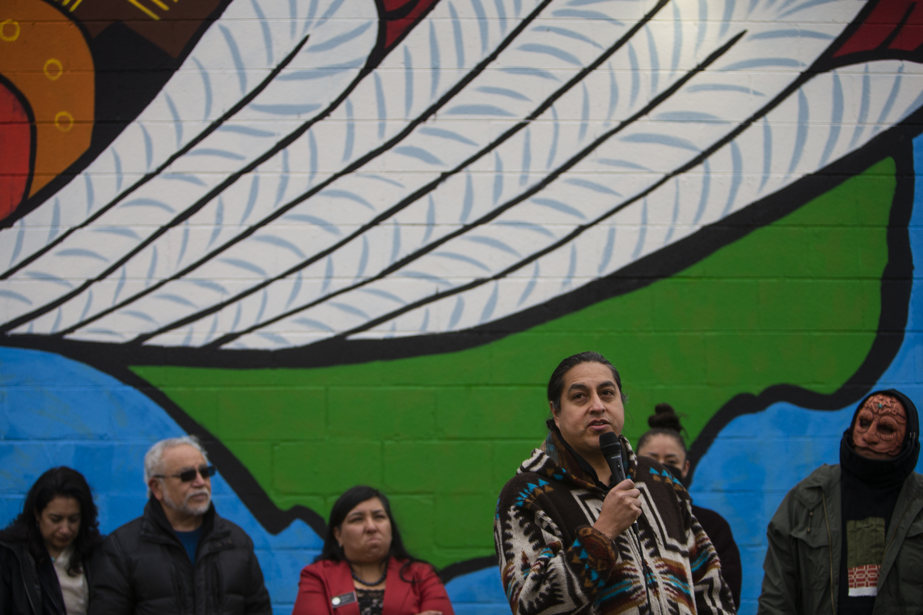 Artist David Ocelotl Garcia speaks speaks in front of the mural 