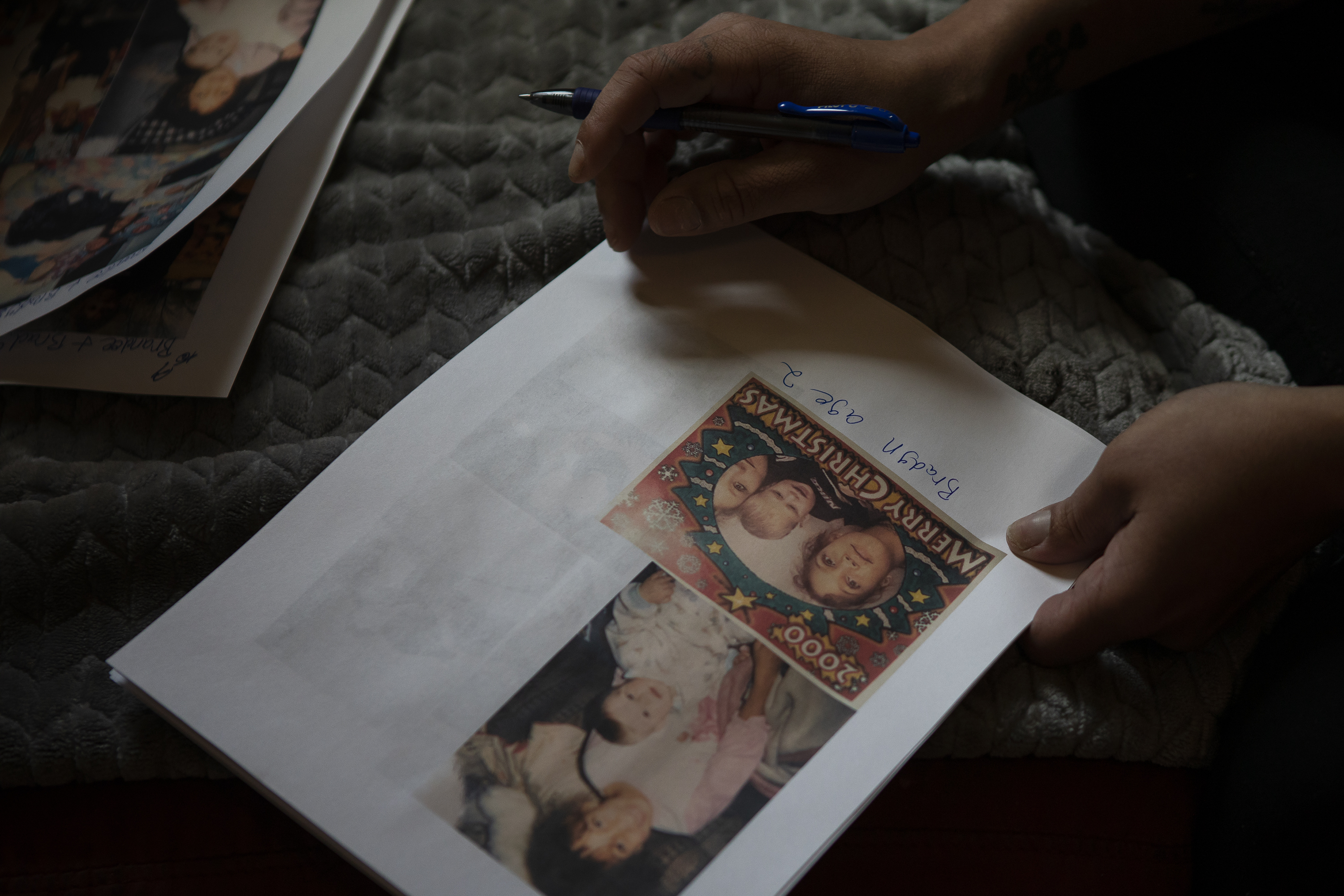 Brandee Lee Eighmy, the older sister of Bradyn Heit, writes the names of Heit and everyone else in family photos on Monday, April 4, 2022, at her home in Aurora, Colo. (Timothy Hurst/The Denver Gazette) (Timothy Hurst)