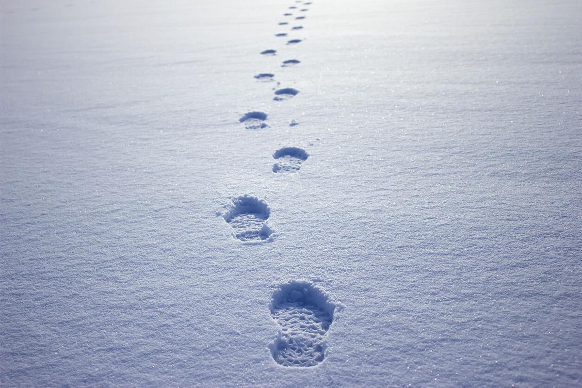 Human footprints in the snow under sunlight close-up view File photo. Photo Credit: alzay (iStock).