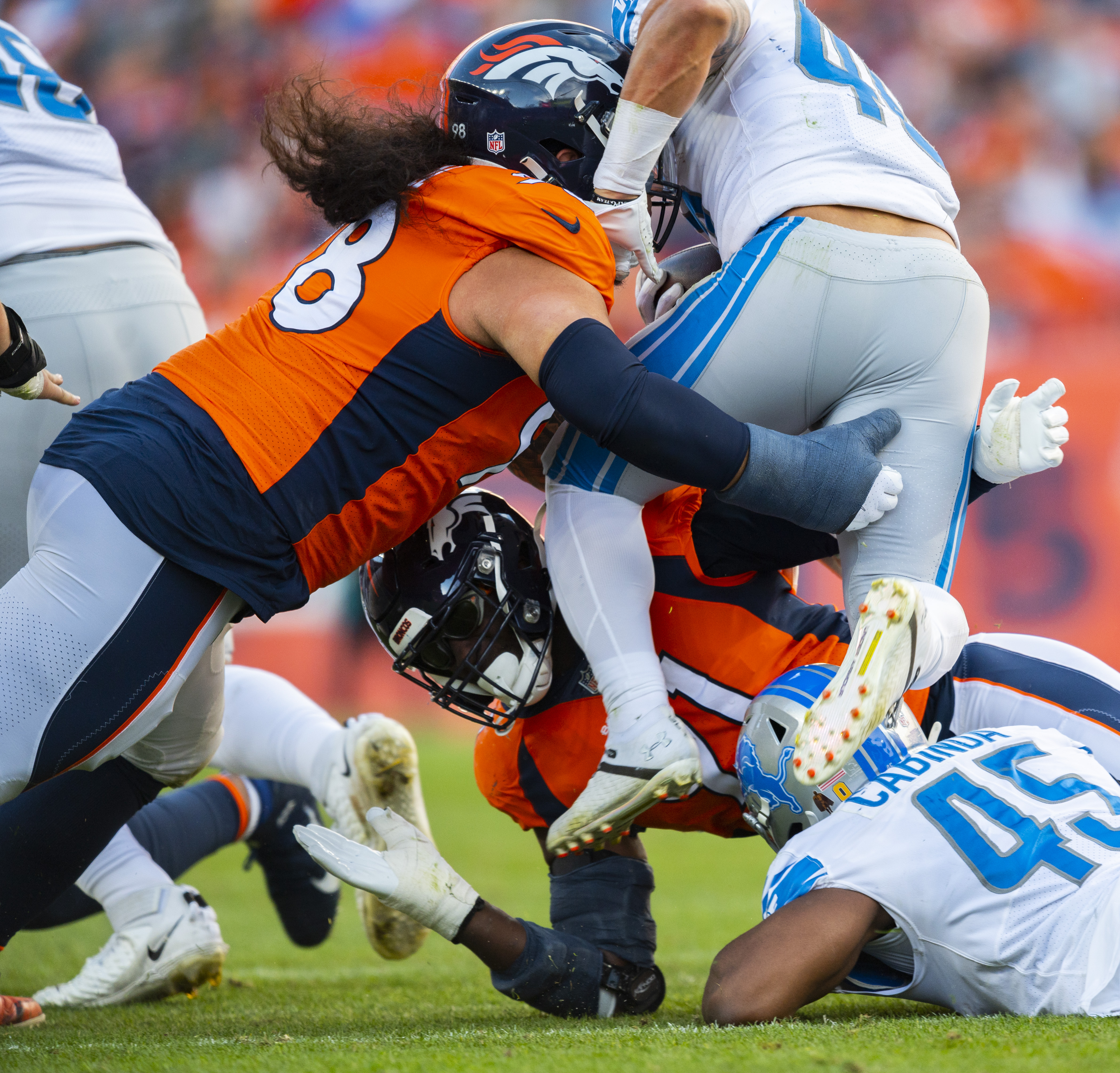 Denver Broncos nose tackle Mike Purcell (98) and inside linebacker Kenny Young (41) tackle Lions running back Craig Reynolds after a short gain during the second quarter Sunday, Dec. 12, 2021, at Empower Field at Mile High in Denver. (The Gazette, Christian Murdock) (Christian Murdock/The Gazette)