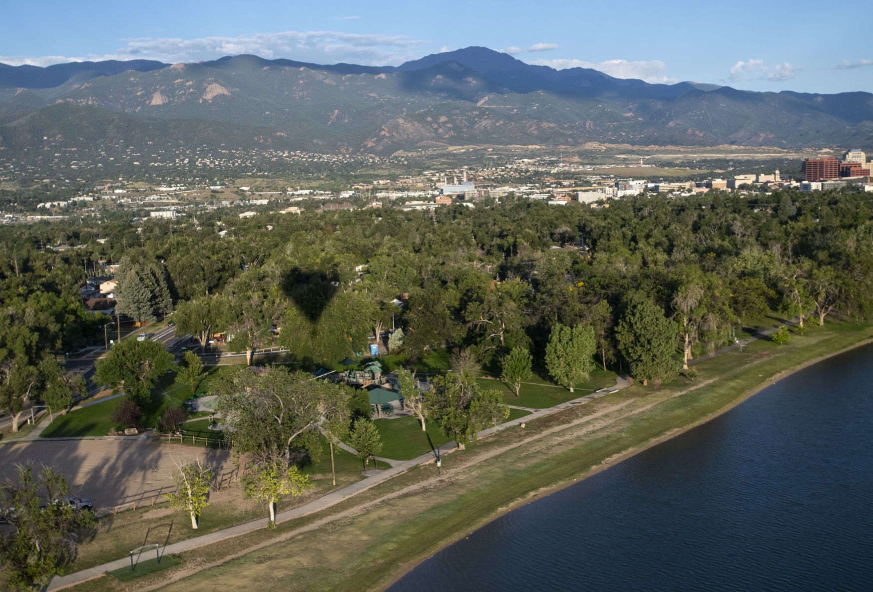 A hot air balloon casts a shadow on the trees surrounding Prospect Lake on Friday, Sept. 2, 2022. (The Gazette, Parker Seibold) (The Gazetter Parker Seibold)