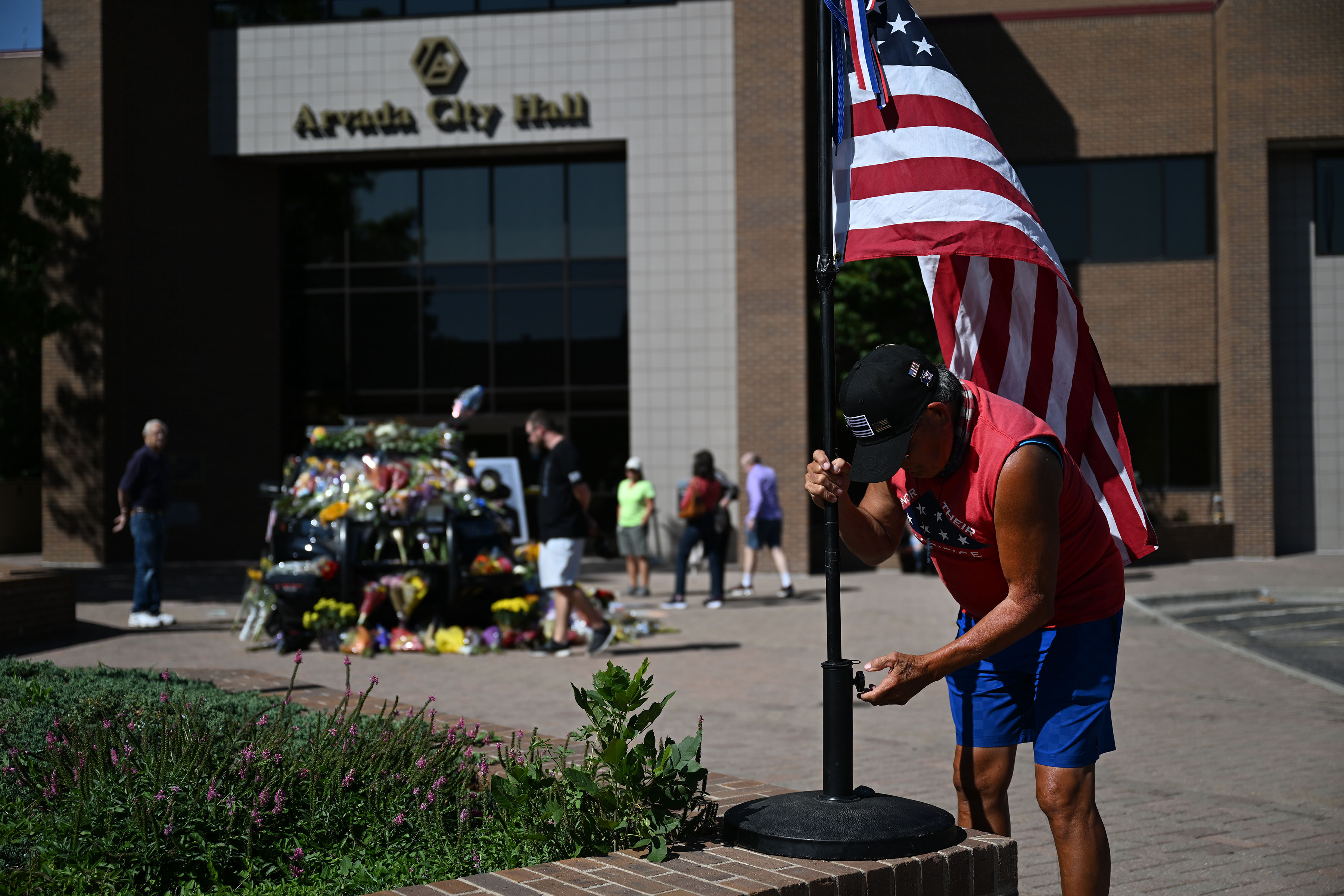 Joe Duran sets up an American flag near the a police cruiser being used as a memorial for fallen Arvada Police officer Dillon Vakoff on Monday, Sept. 12, 2022, in Arvada, Colo. Vakoff was killed in the line of duty early Sunday morning. (Timothy Hurst/The Denver Gazette) (Timothy Hurst)