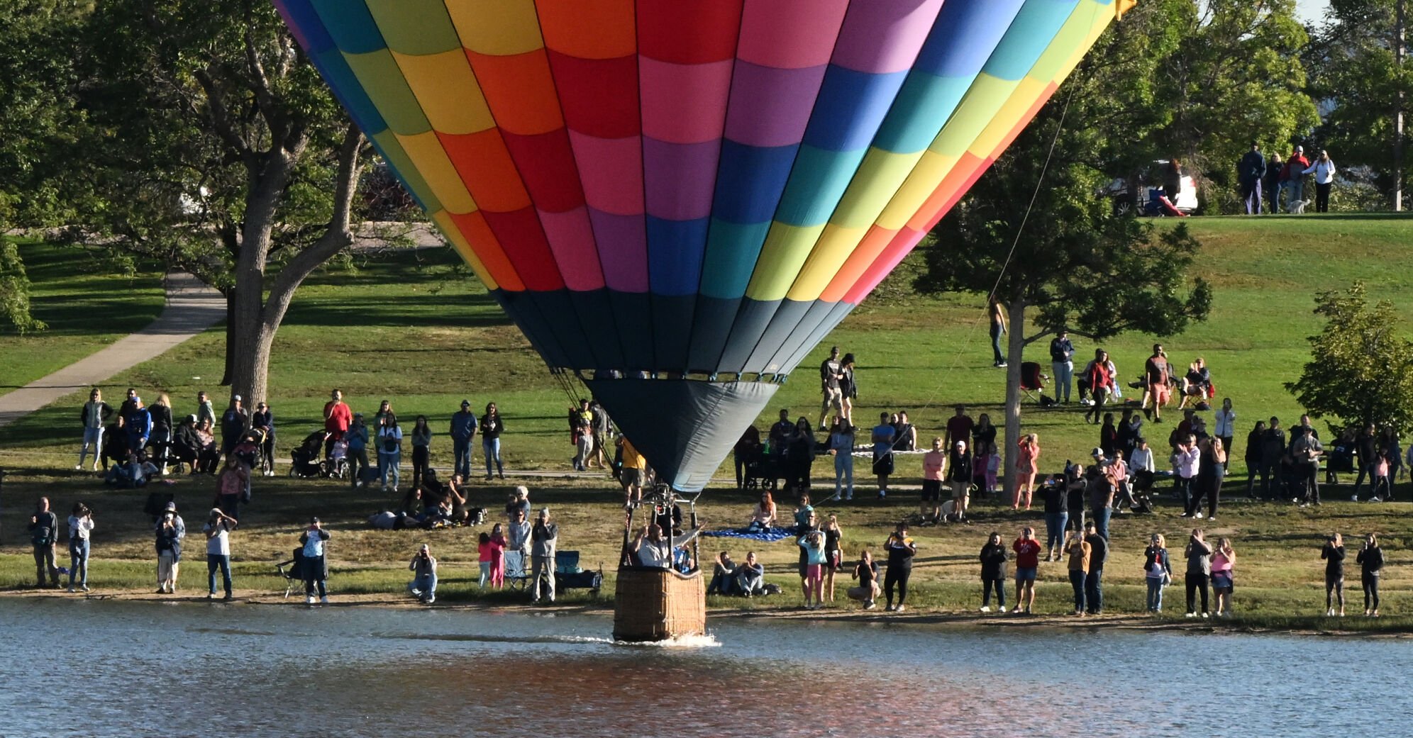 The crowd cheers as a balloon dips in Prospect Lake during the Labor Day Lift Off. (Photo by Jerilee Bennett, The Gazette) (Jerilee Bennett)